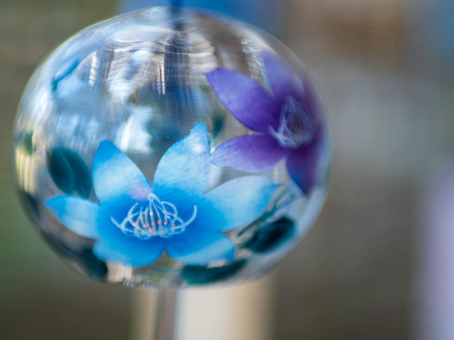 Hermosa esfera decorativa con flores azules y moradas en su interior