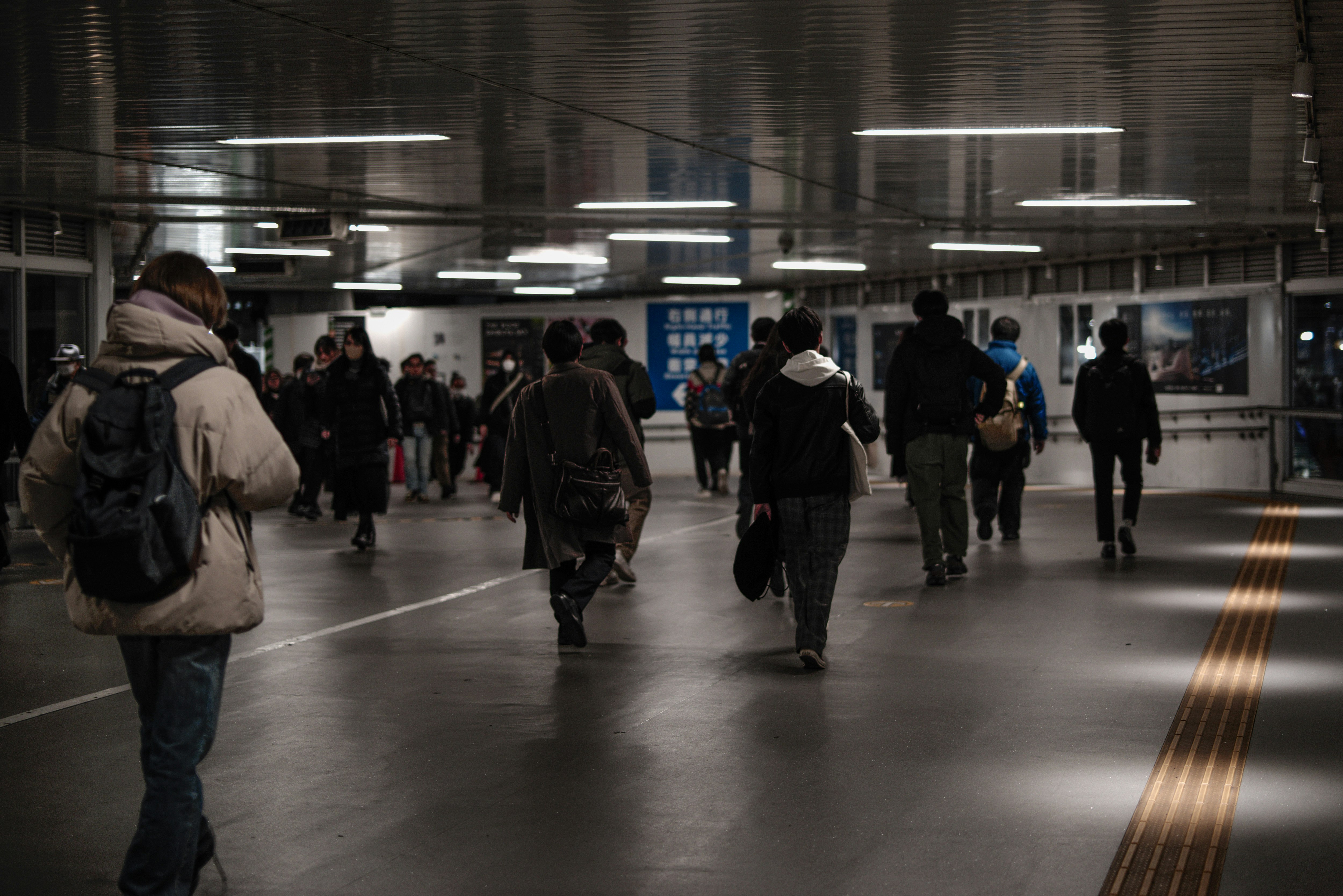 Passaggio sotterraneo della stazione di Shibuya con persone che camminano
