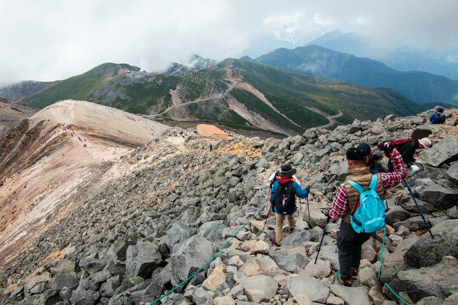 Escursionisti che attraversano un terreno roccioso in un paesaggio montano