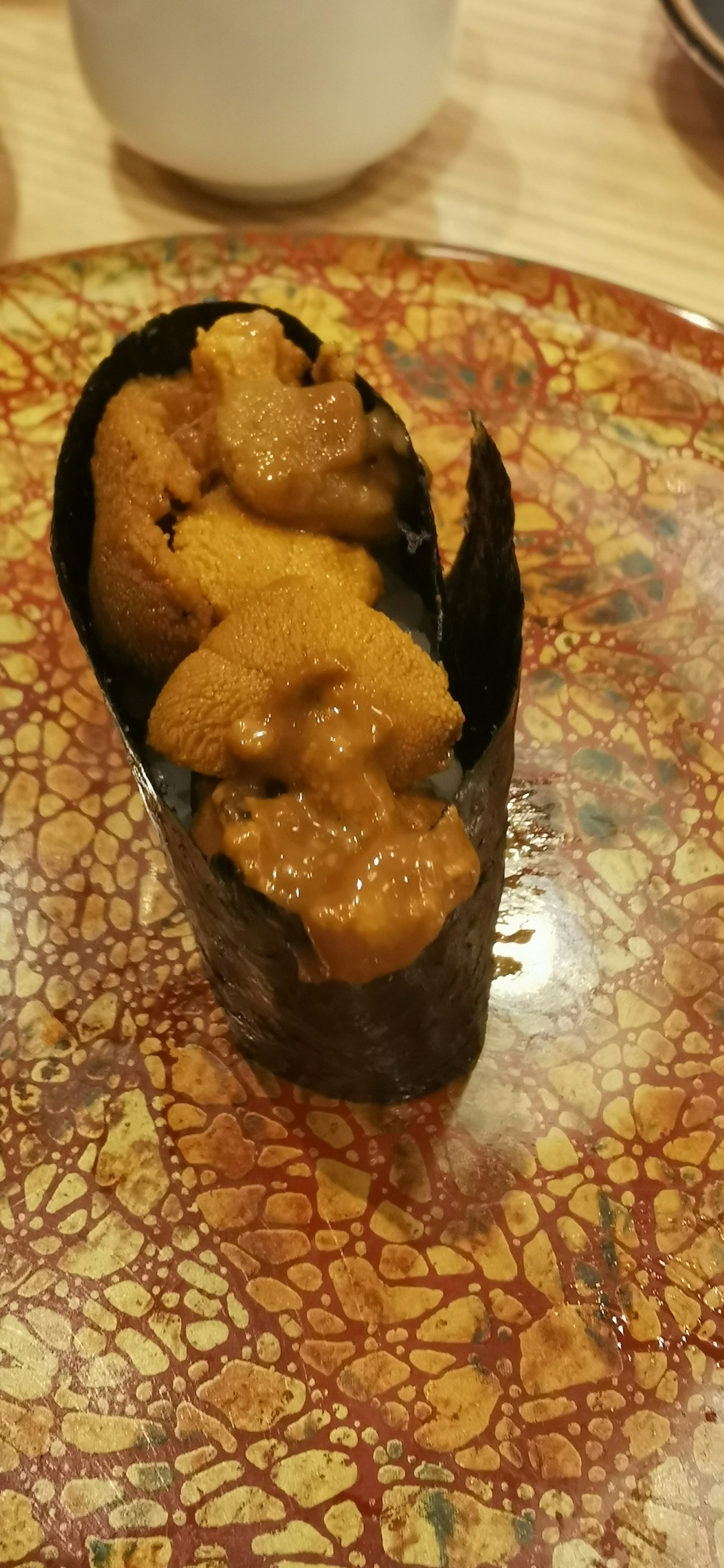 Sushi d'oursin enveloppé dans une algue sur une assiette