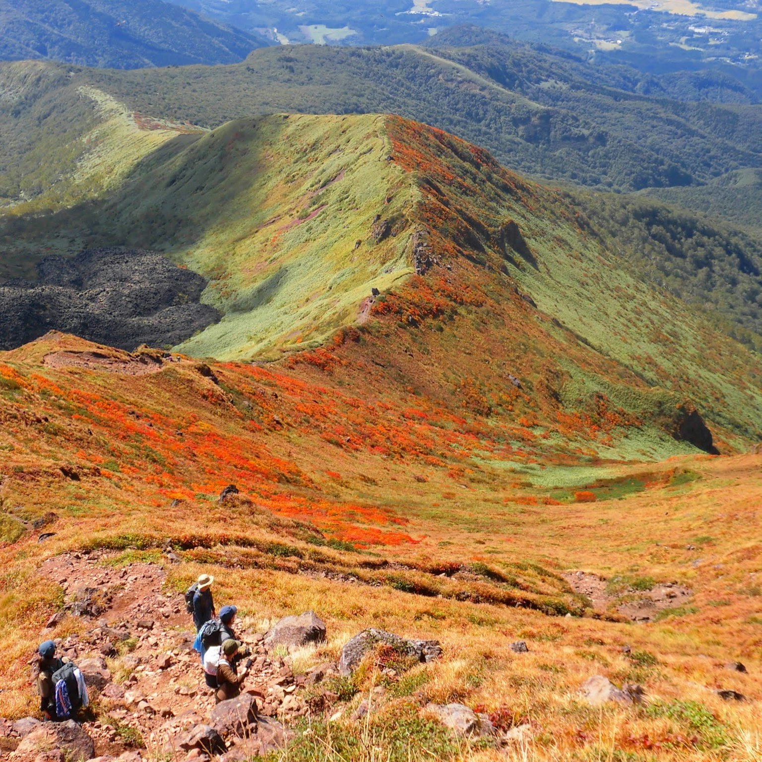 Mountain landscape with colorful grasslands and hikers