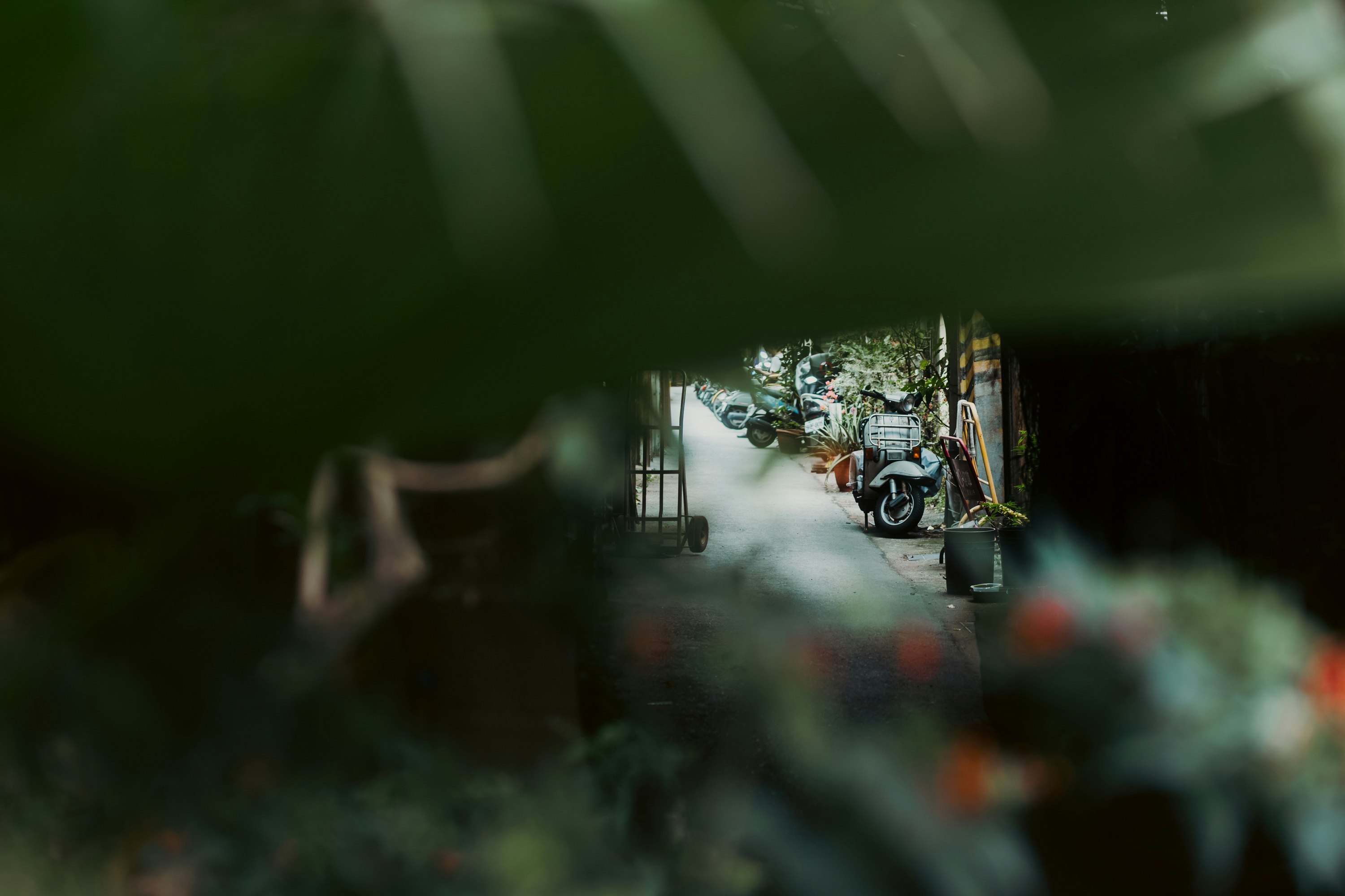 路地の奥に停まるバイクと自転車のある商店街の軒先