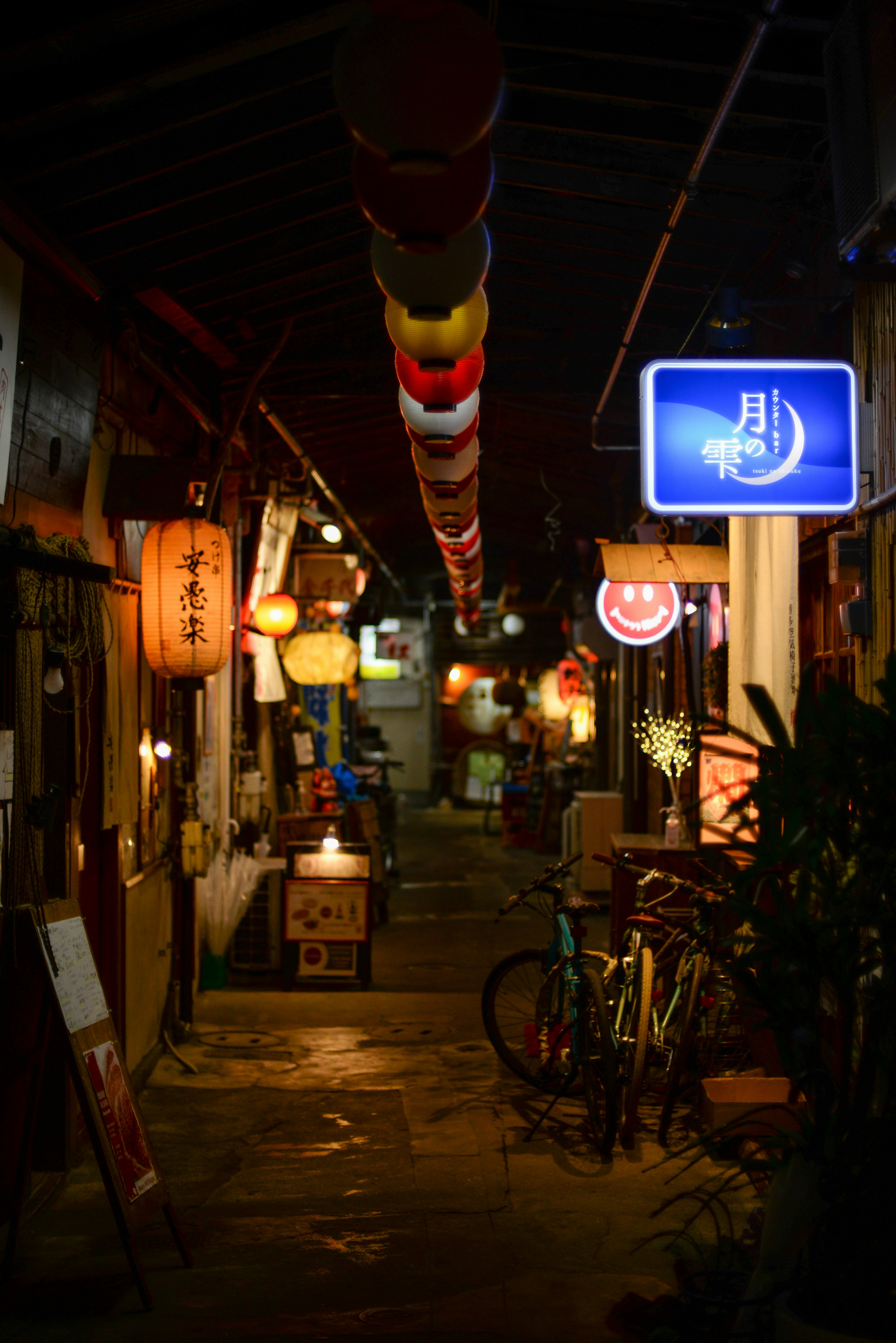提灯と自転車が並ぶ路地の夜景