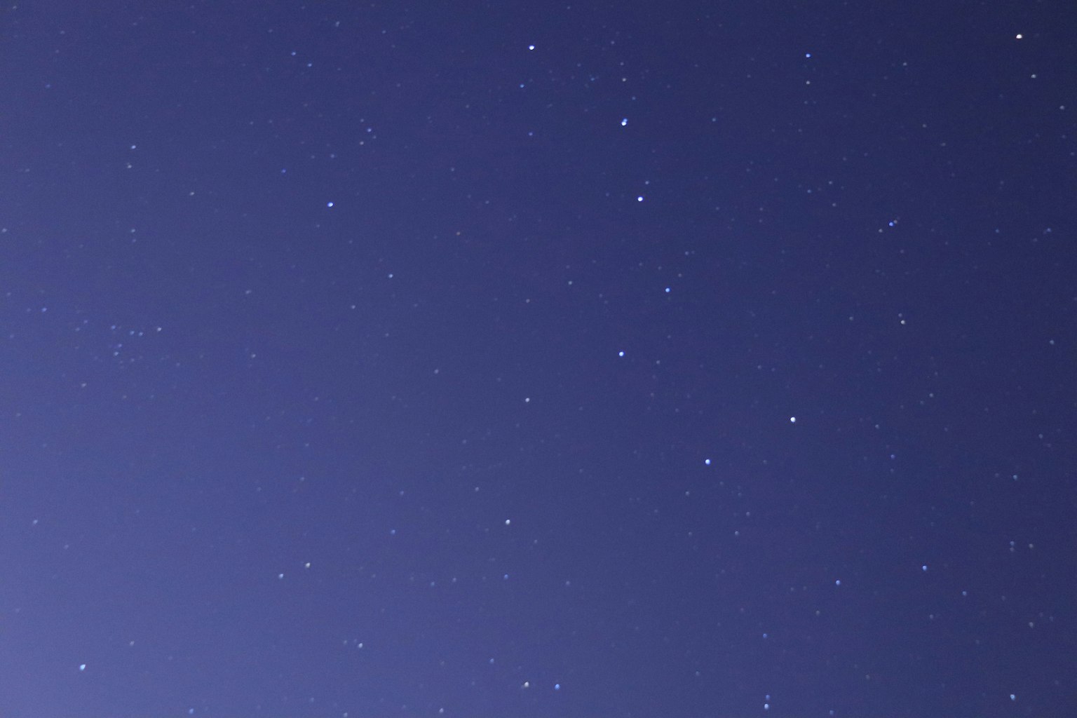 Langit malam dengan bintang bersinar di latar belakang biru tua