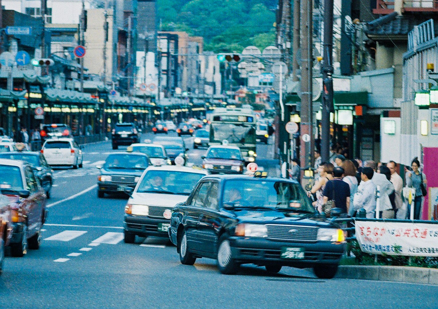 Scena di strada affollata con auto e pedoni