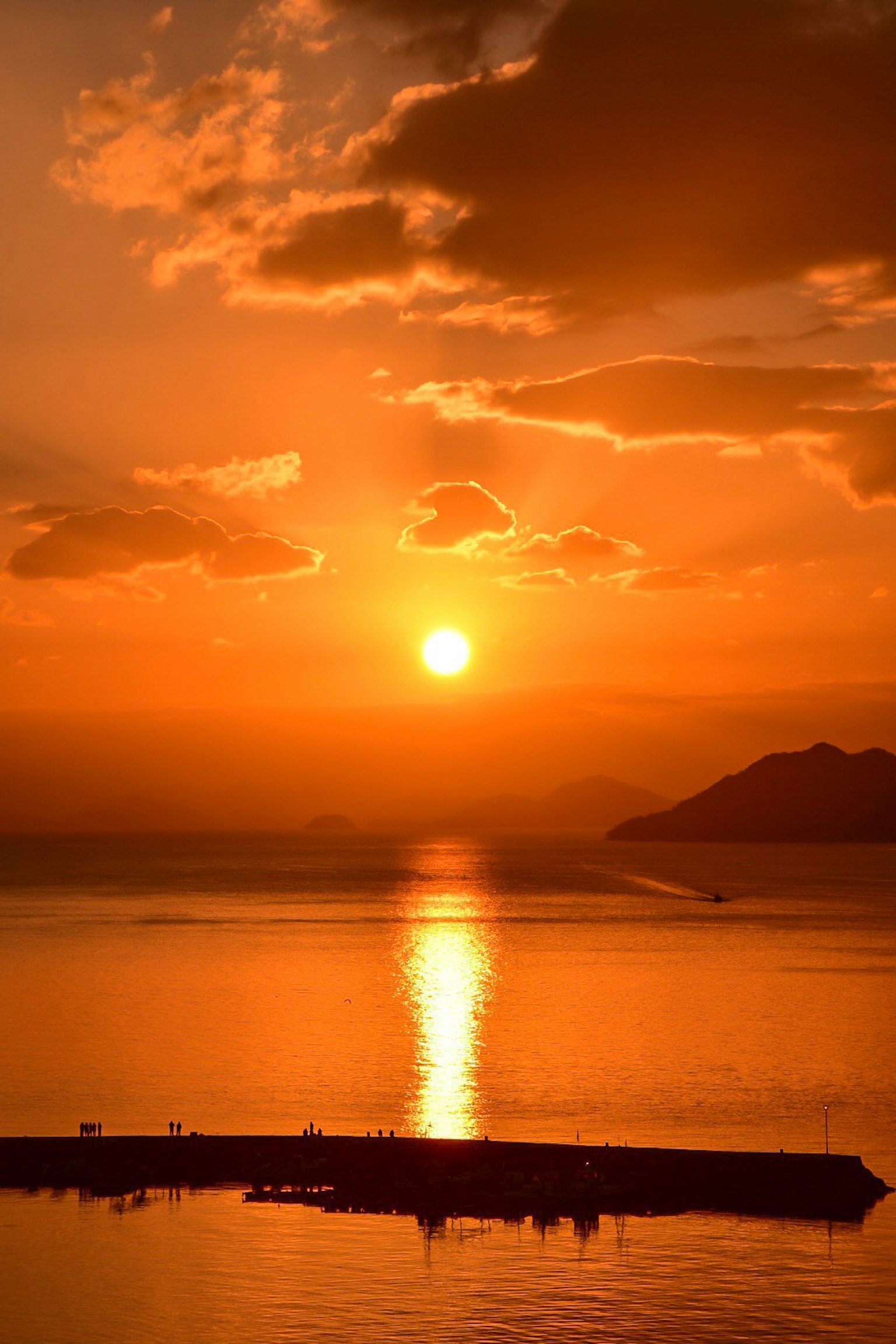 Bellissima vista del tramonto sul mare con un cielo arancione vibrante e riflesso sull'acqua