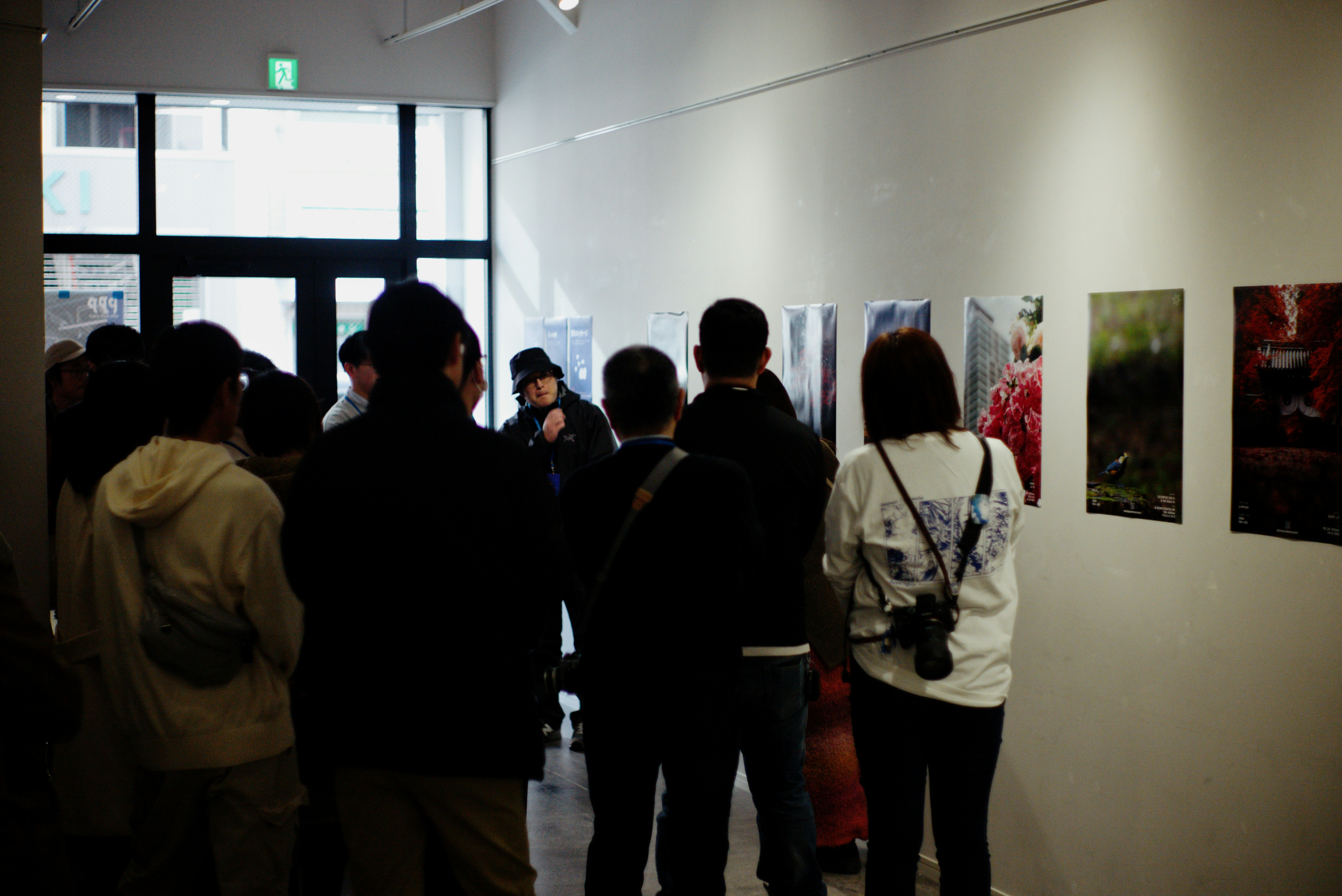 京都のギャラリーで展示作品を見つめる来場者の列