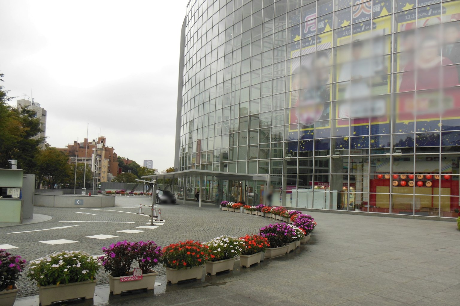 Modernes Glasgebäude mit bunten Blumenbeeten im Vordergrund