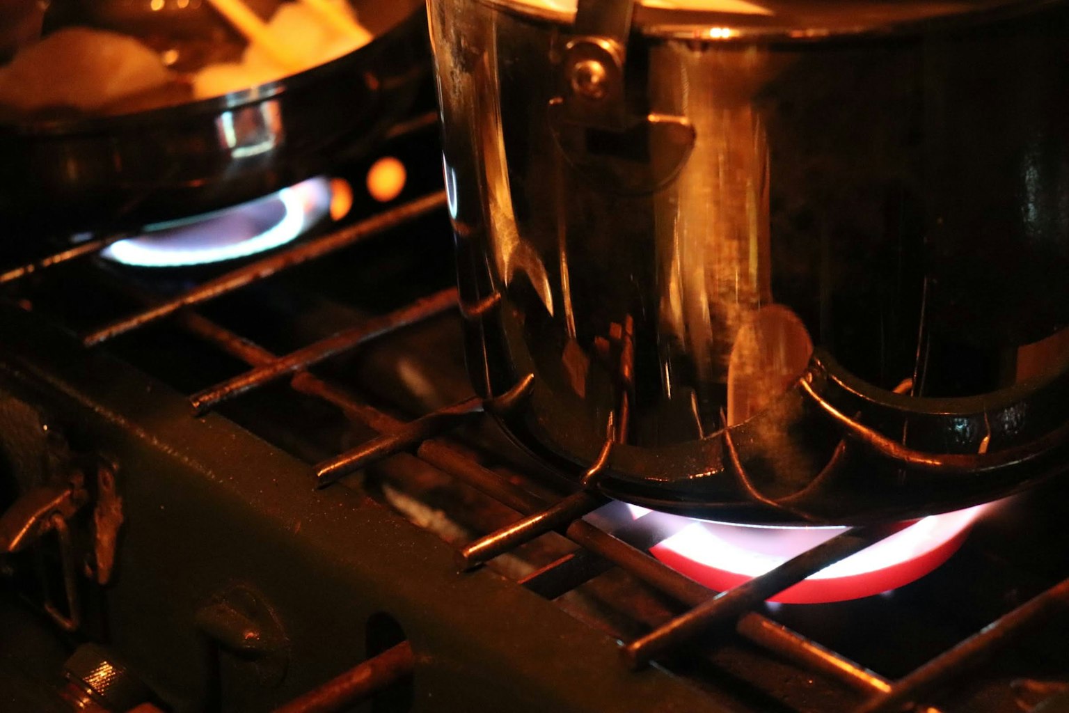 Una olla cocinando en una estufa de gas con llamas visibles