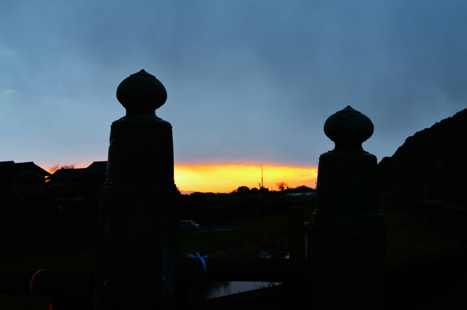 Dos estatuas en silueta contra un vibrante atardecer