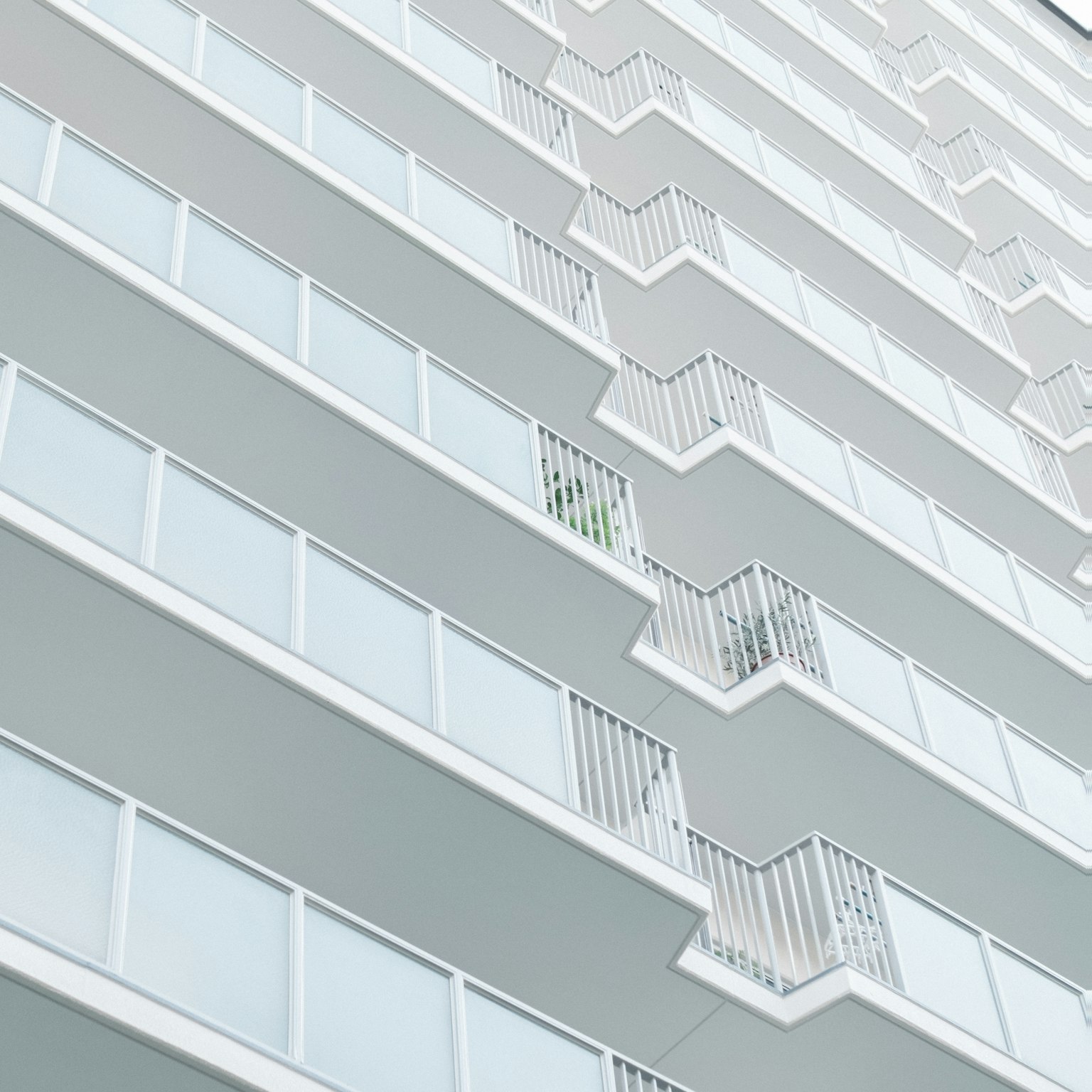 Eksterior gedung tinggi modern dengan balkon putih