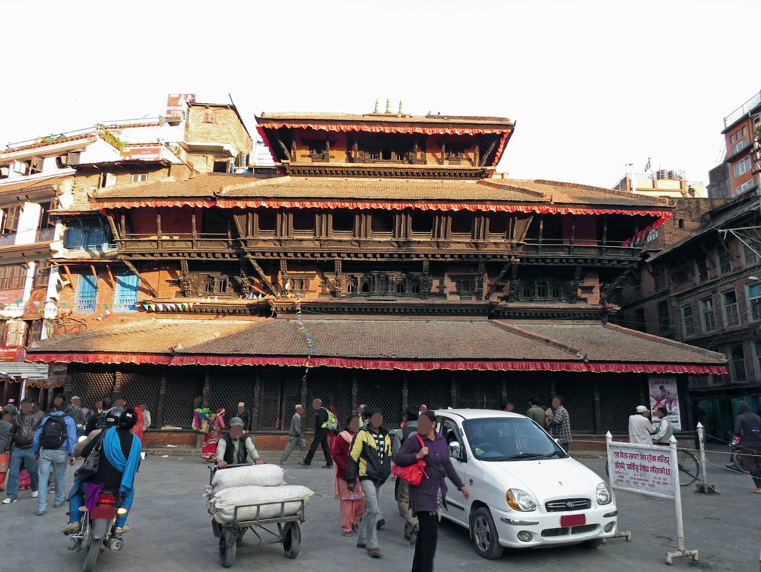 Bangunan tradisional di Kathmandu dengan orang-orang berkumpul di sekitarnya