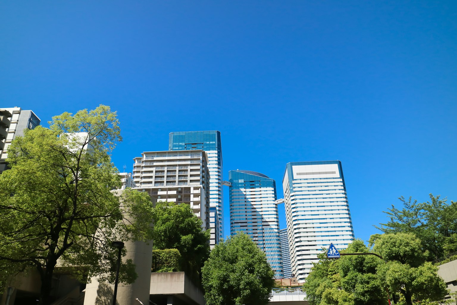 Garis langit kota dengan gedung-gedung tinggi di bawah langit biru yang cerah