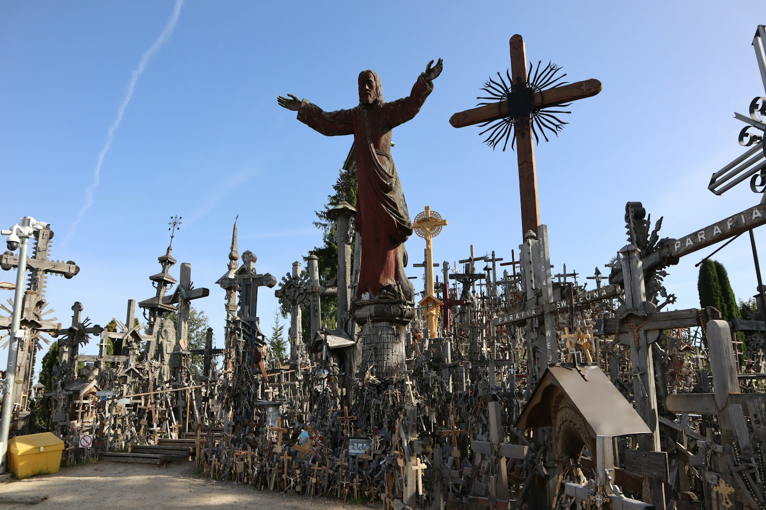 Un paisaje de un sitio sagrado lleno de numerosas cruces con una estatua central de Cristo