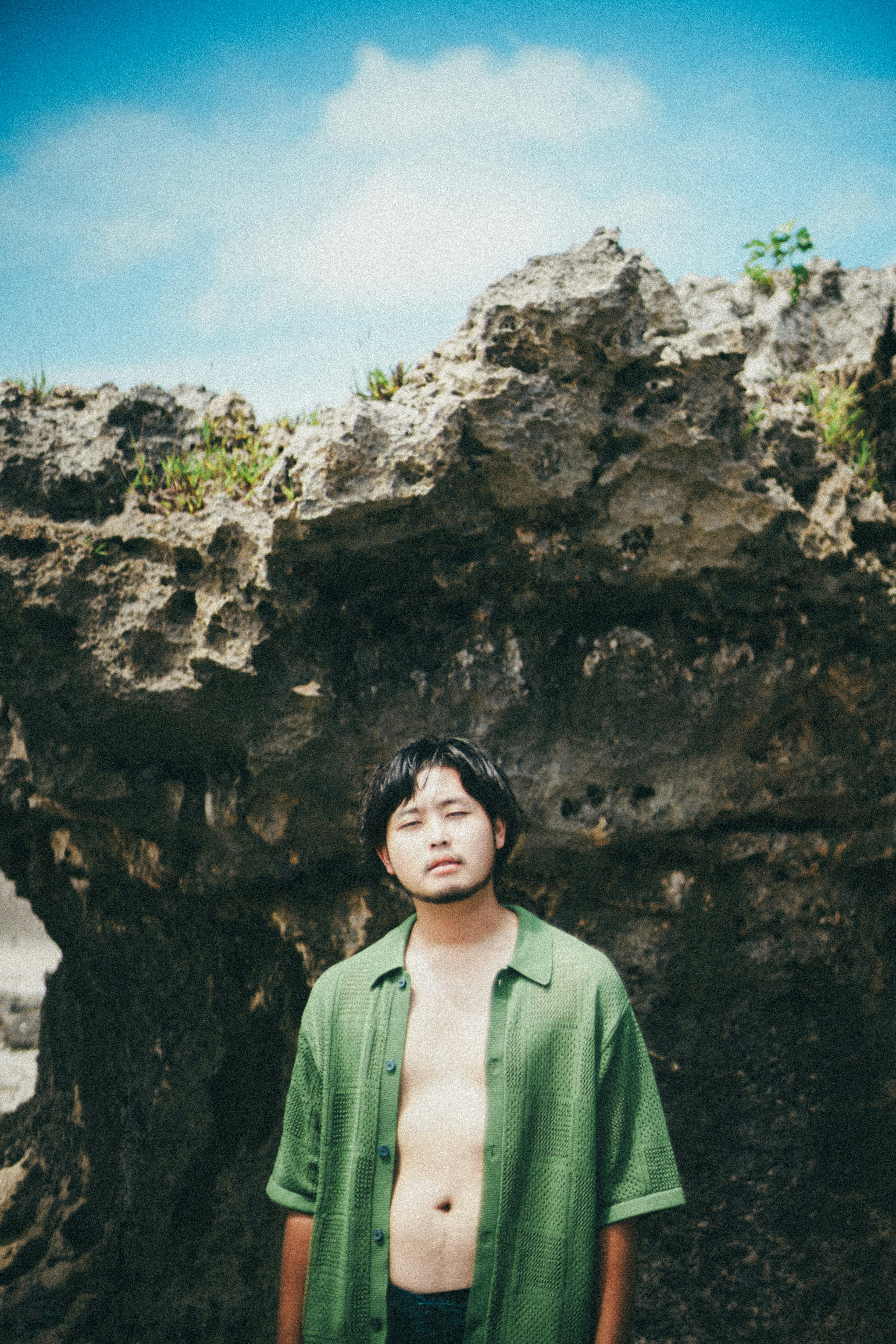 man standing in front of a rocky cliff image