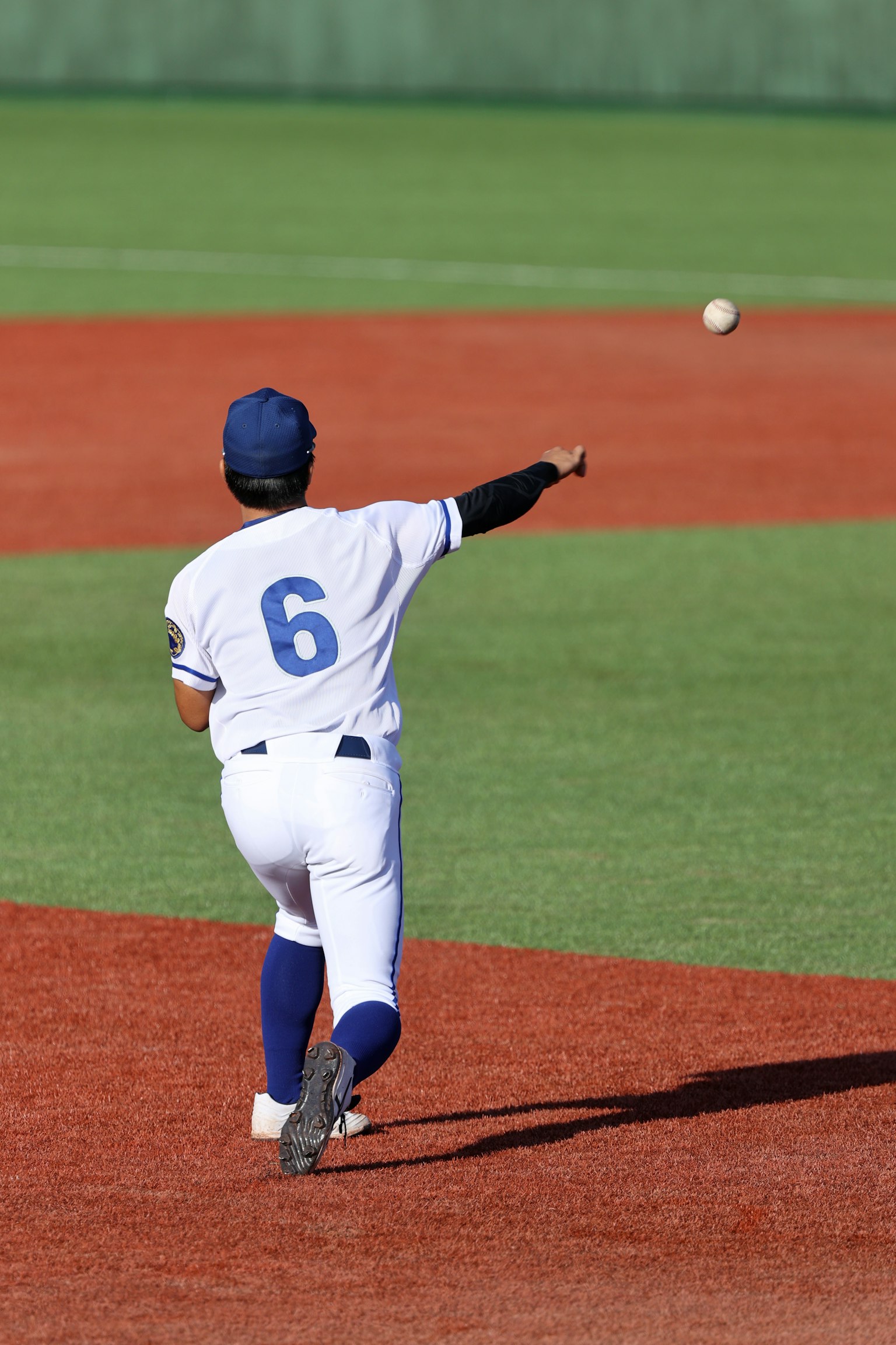 Giocatore di baseball che lancia una palla con il numero 6