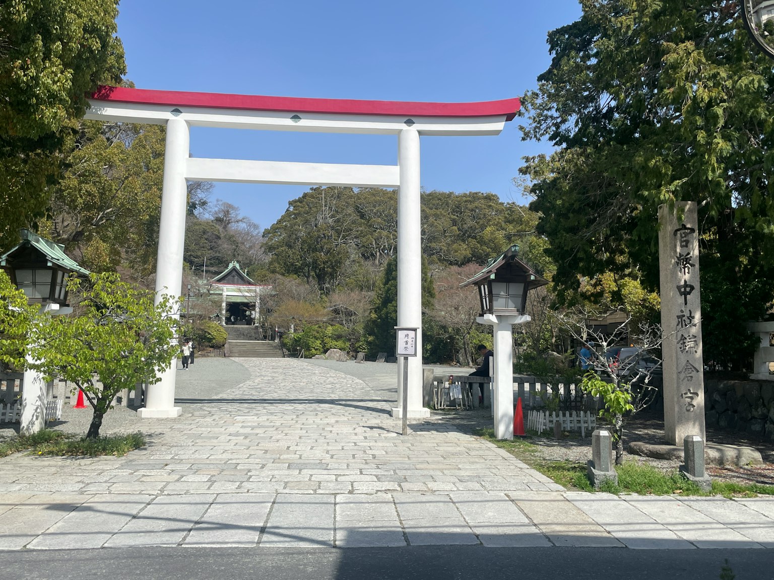 Eingang eines Schreins mit einem roten Torii und Steingefäßen