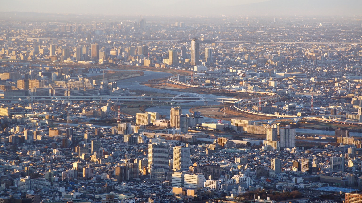 Vista aerea di un paesaggio urbano con edifici residenziali e un fiume al tramonto