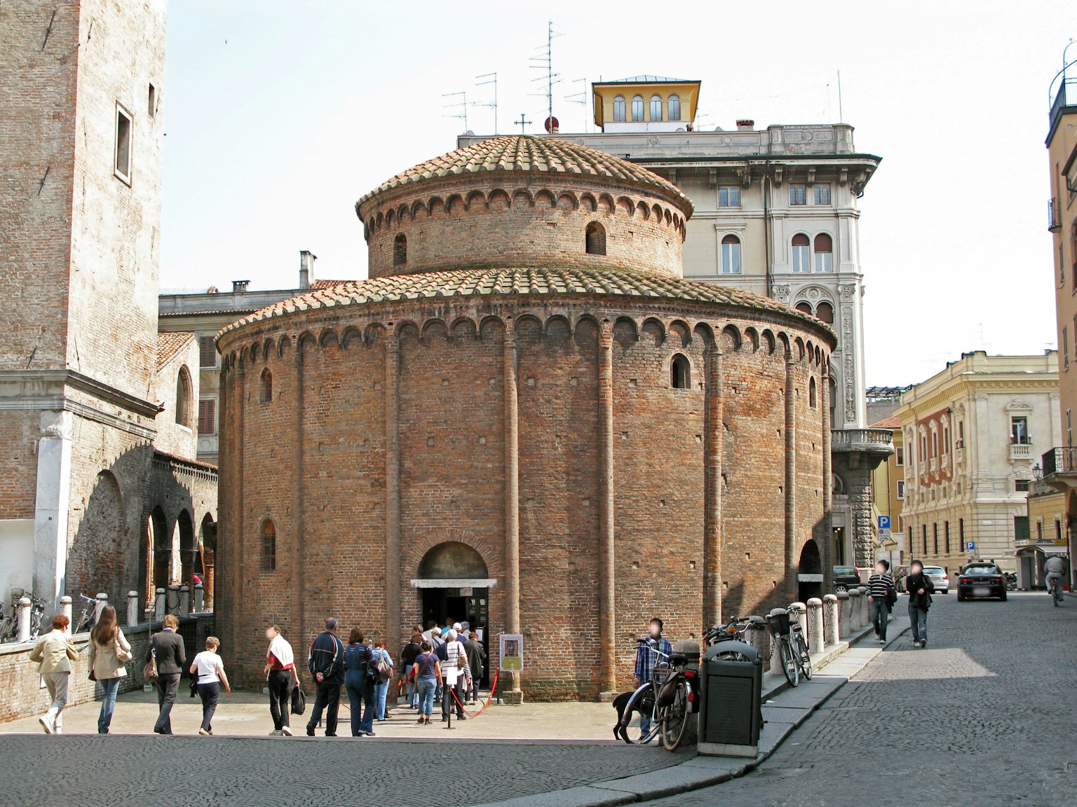 Edificio circolare in mattoni dell'antica Roma con turisti attorno