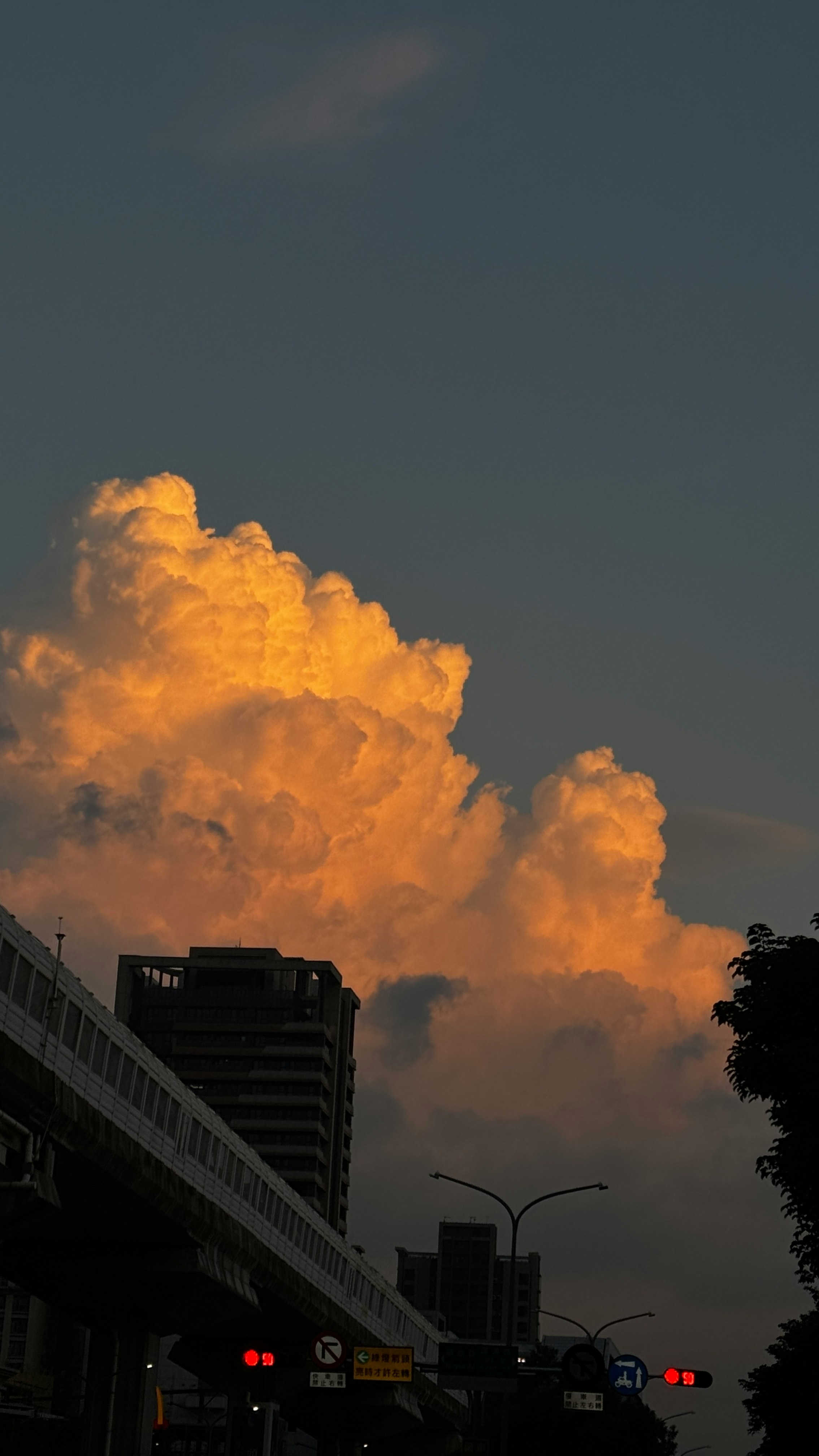 nubes naranjas sobre un paso elevado urbano al atardecer