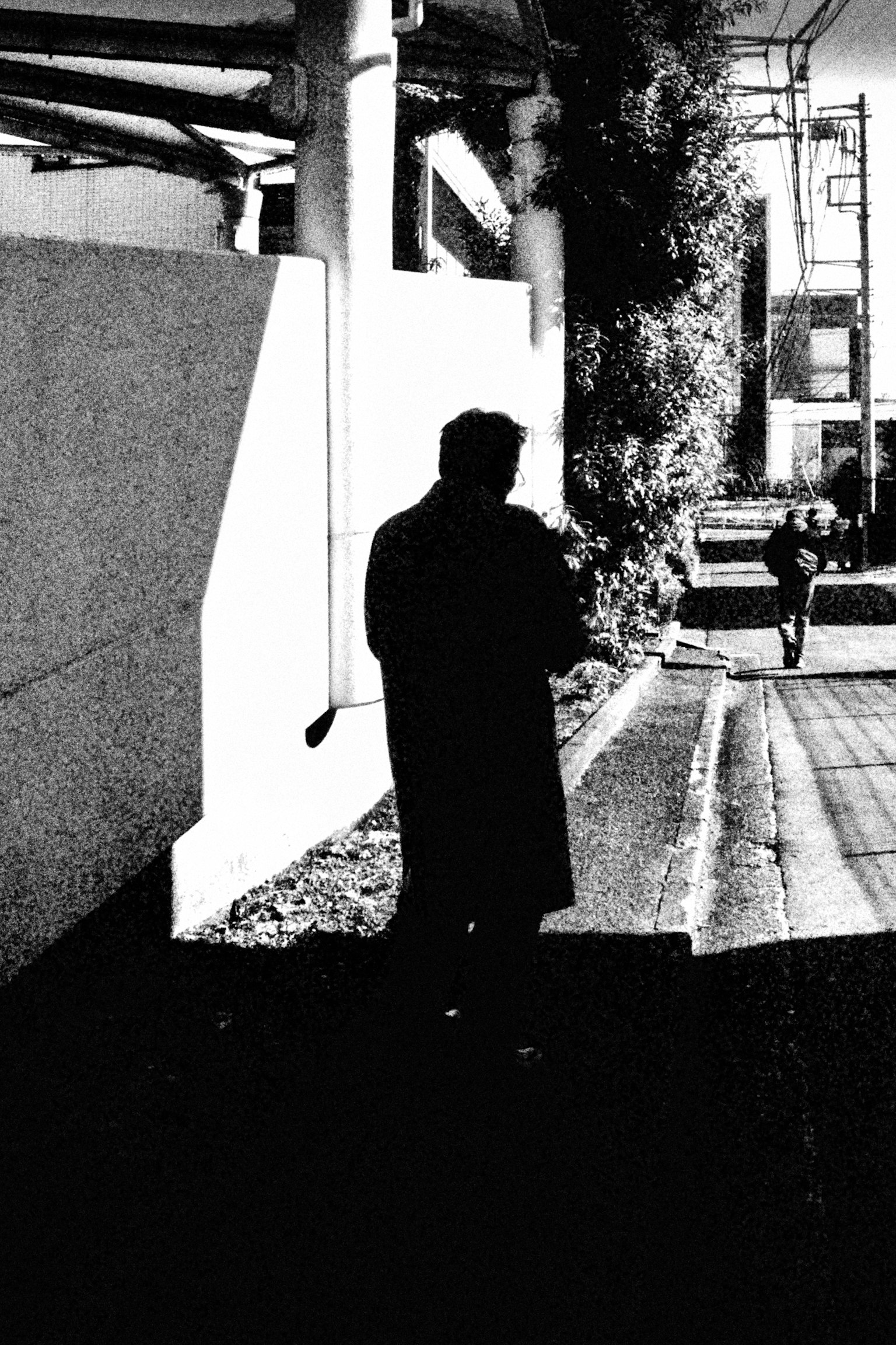 Silhouette of a person walking on a street monochrome image