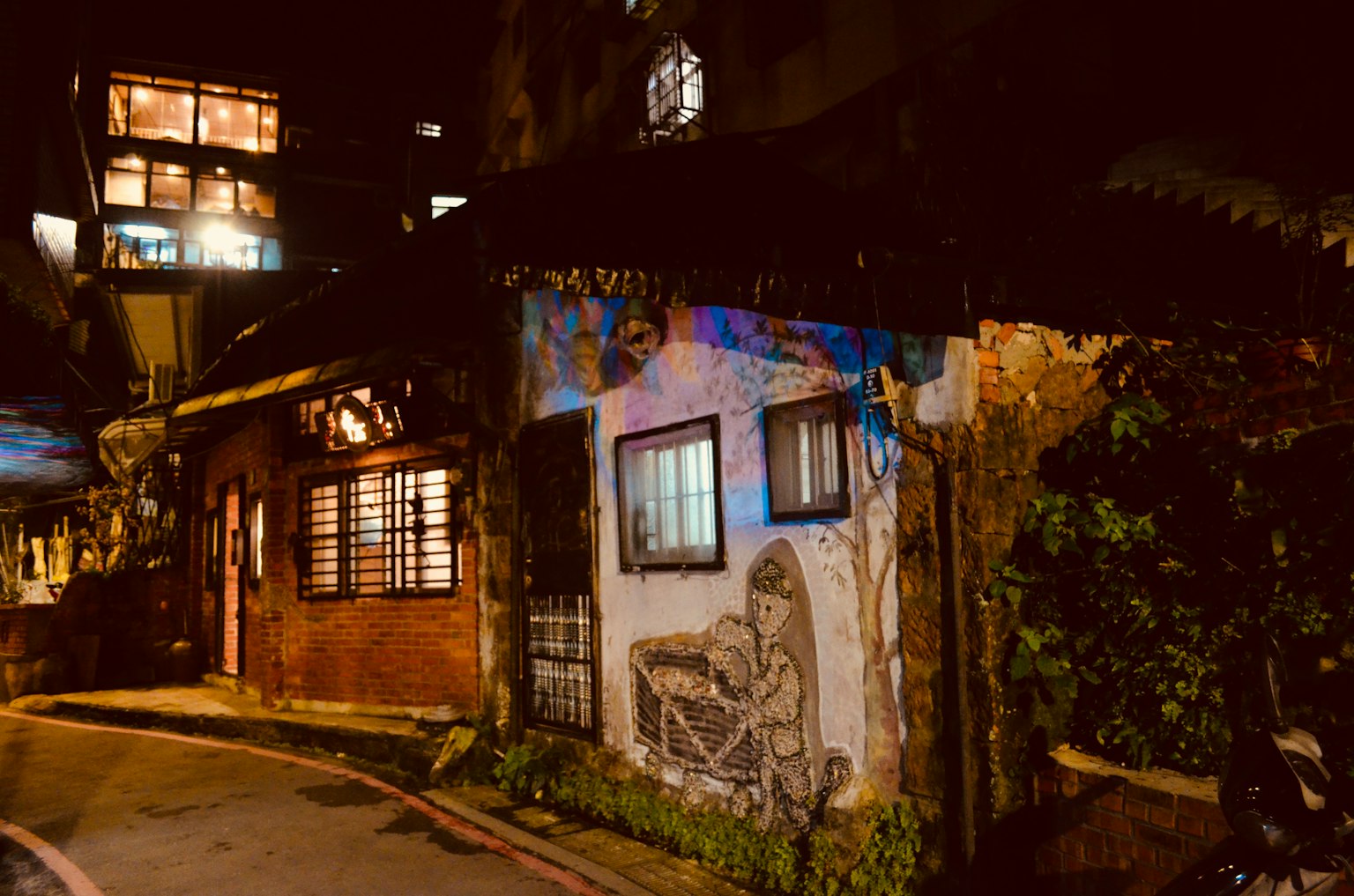 Kunstbedecktes Gebäude an einer Straßenecke bei Nacht