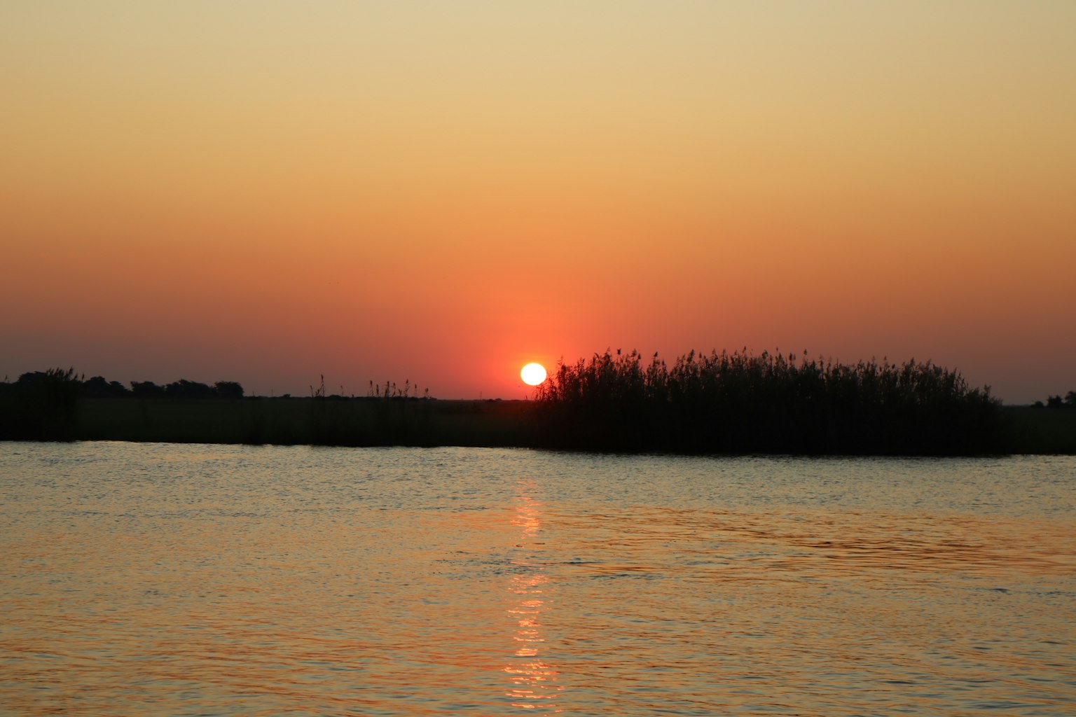 Malersiche Aussicht auf einen Sonnenuntergang, der sich im Wasser spiegelt