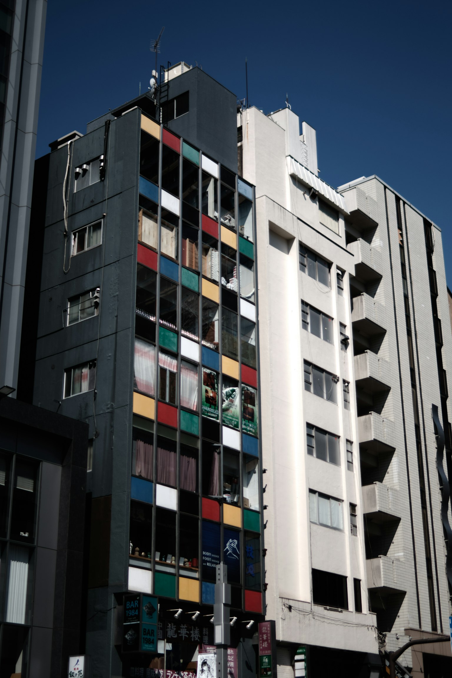 カラフルな外壁を持つ建物の写真　青空の下に立つ多層の構造