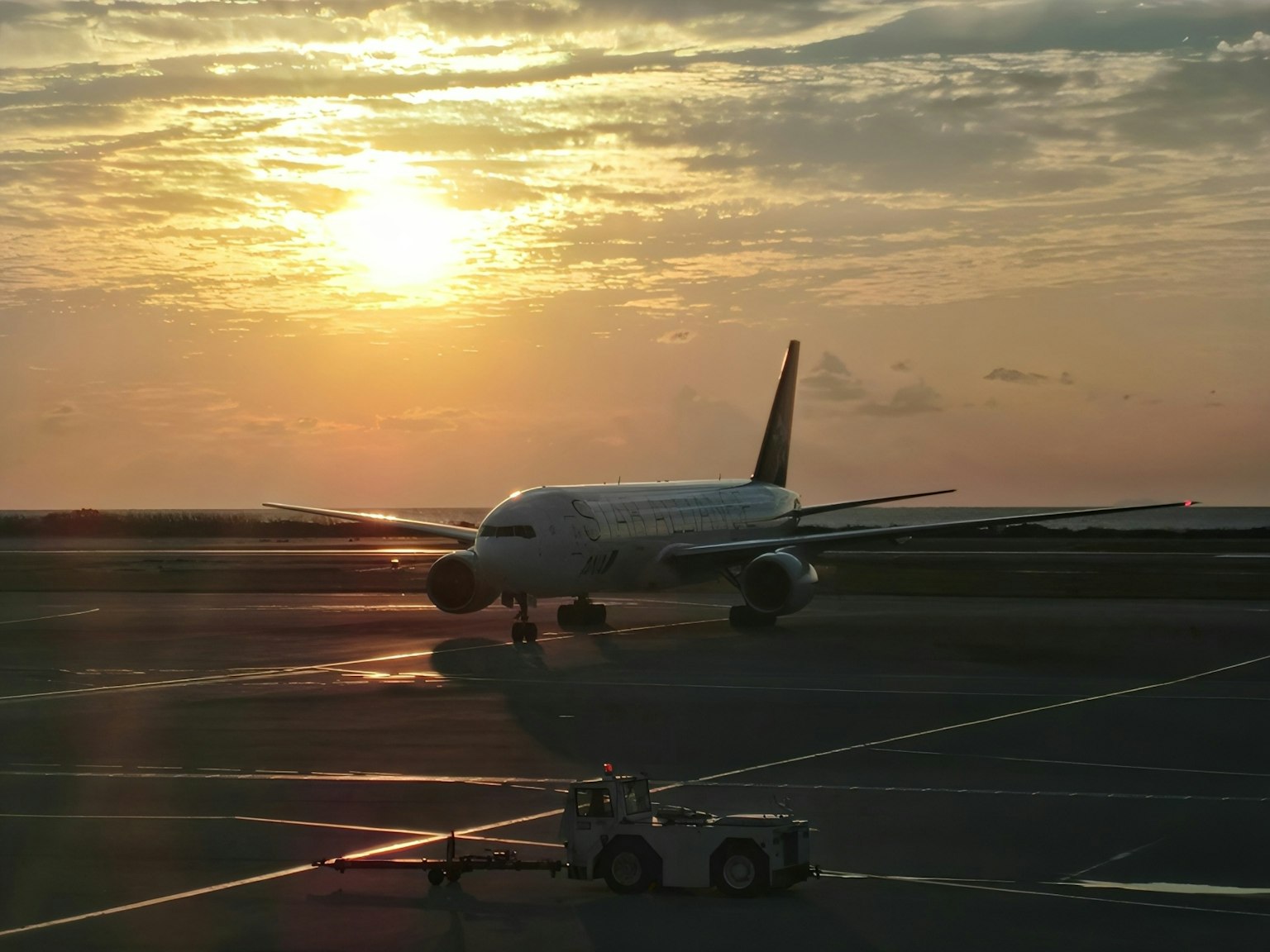 Airplane on the runway with sunset in the background