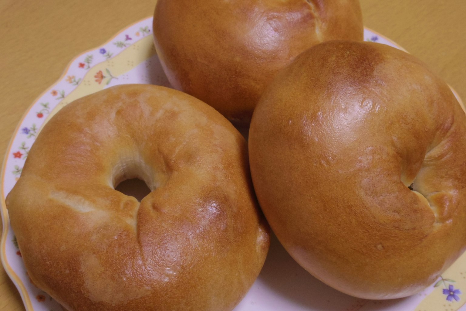 Three bagels placed on a decorative plate