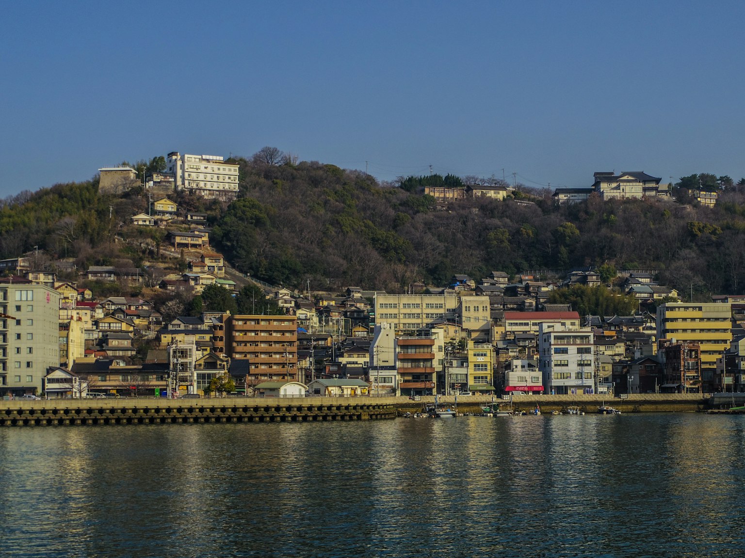 Area residenziale costiera con collina e cielo azzurro