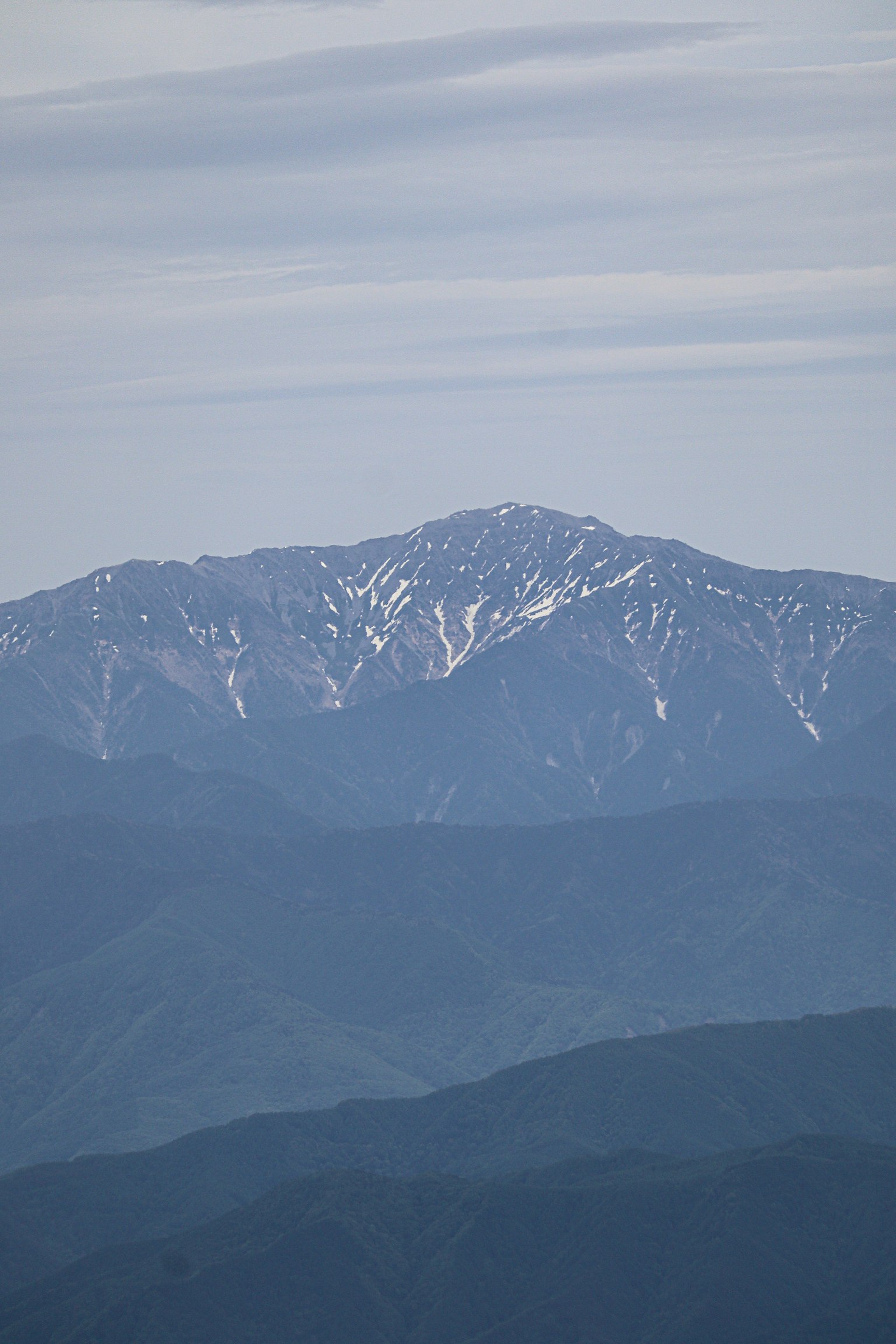 Montagnes lointaines avec un sommet enneigé visible