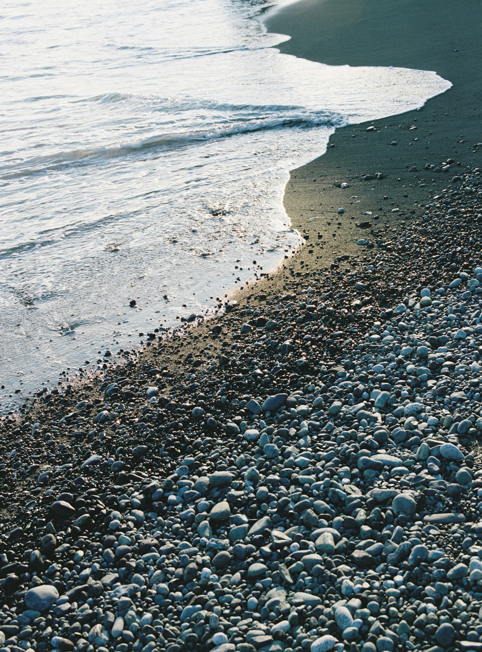 Image capturing the interaction of pebbles and waves on a beach