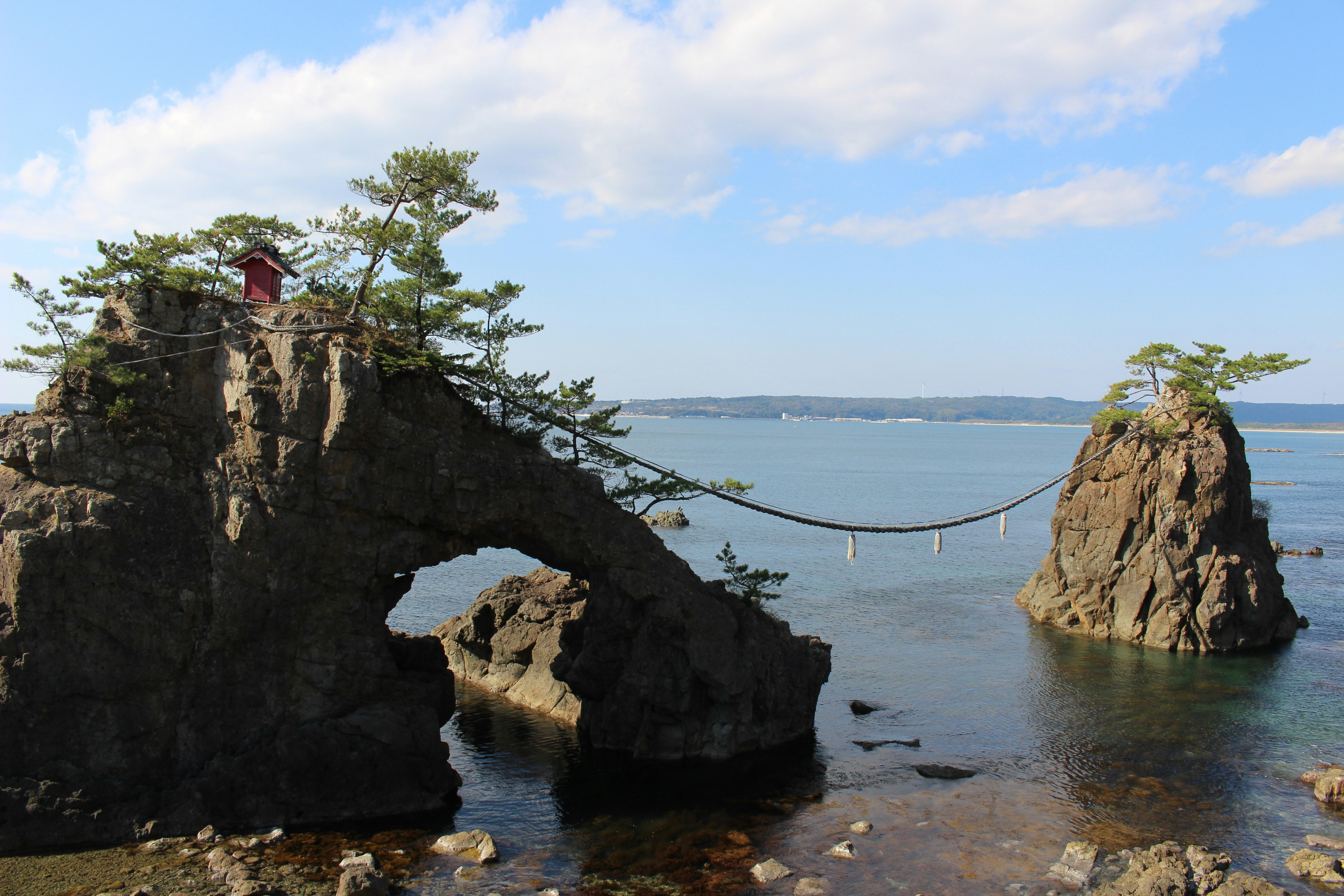 海に突き出す岩とロープのある海岸の景色