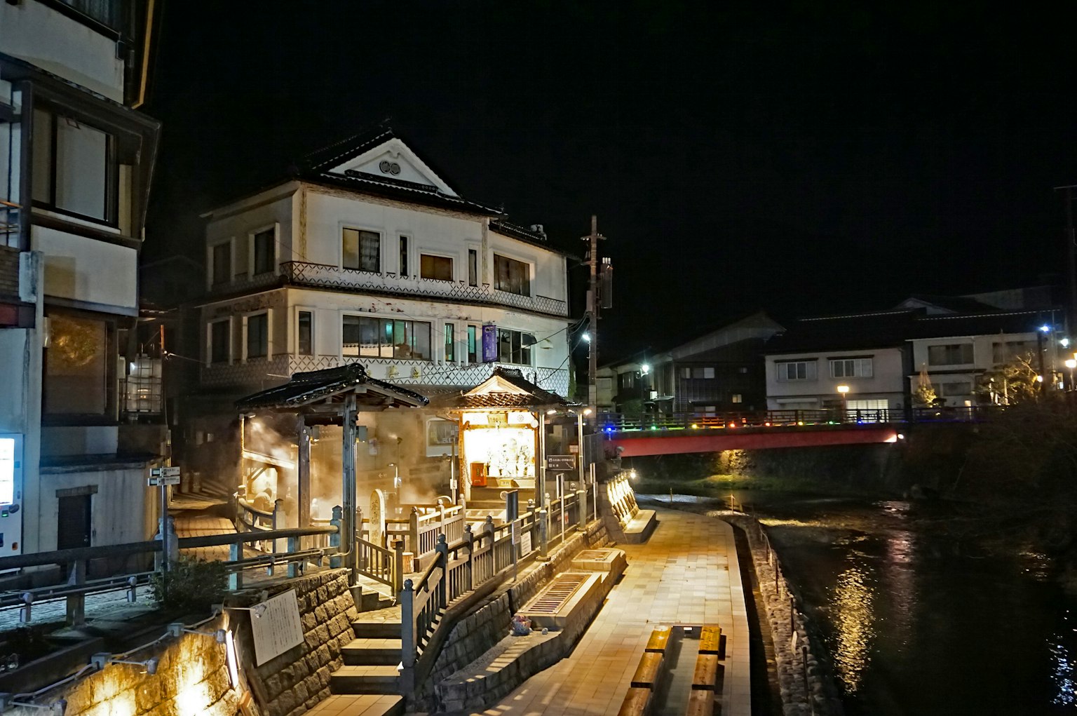 Nachtansicht einer Thermalstadt mit Gebäuden und einem Fluss