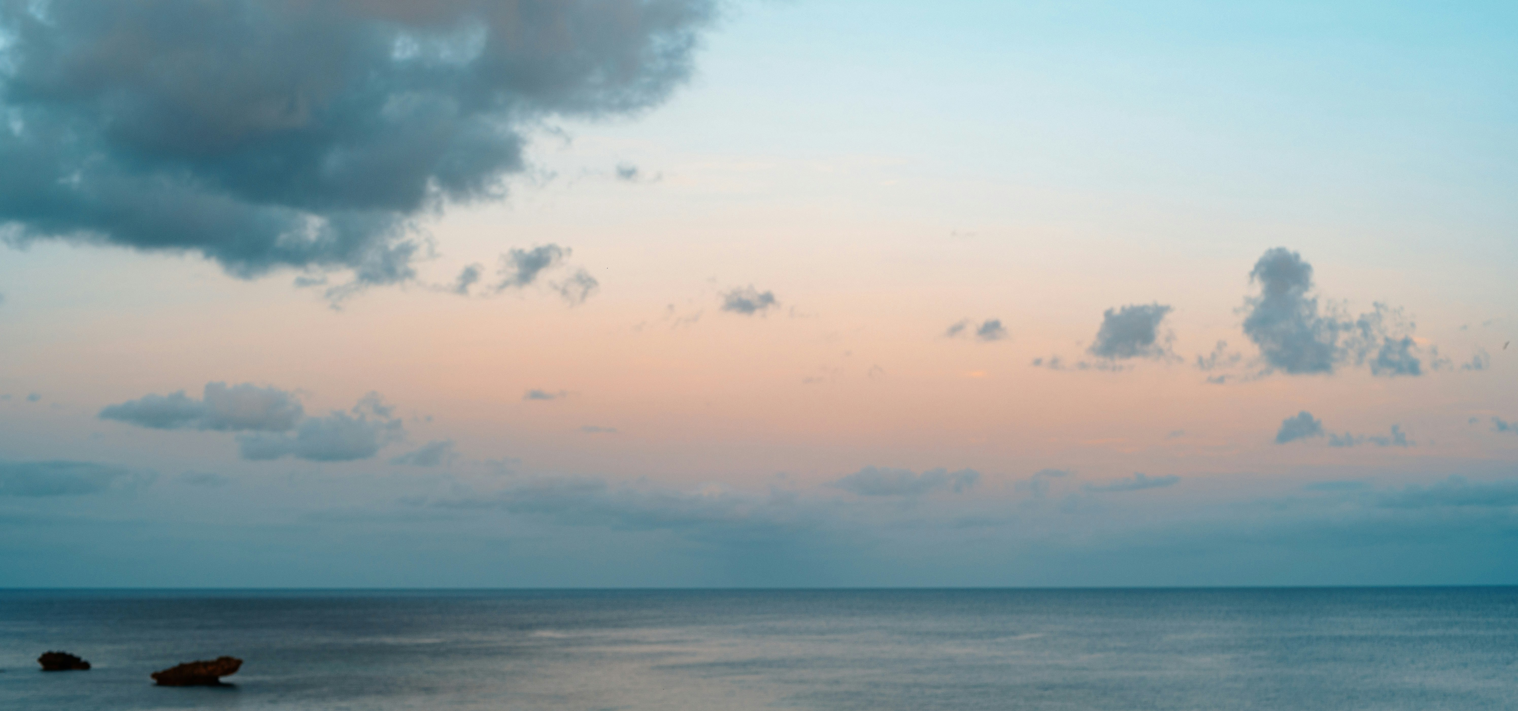 水平線に広がる海と夕暮れの雲
