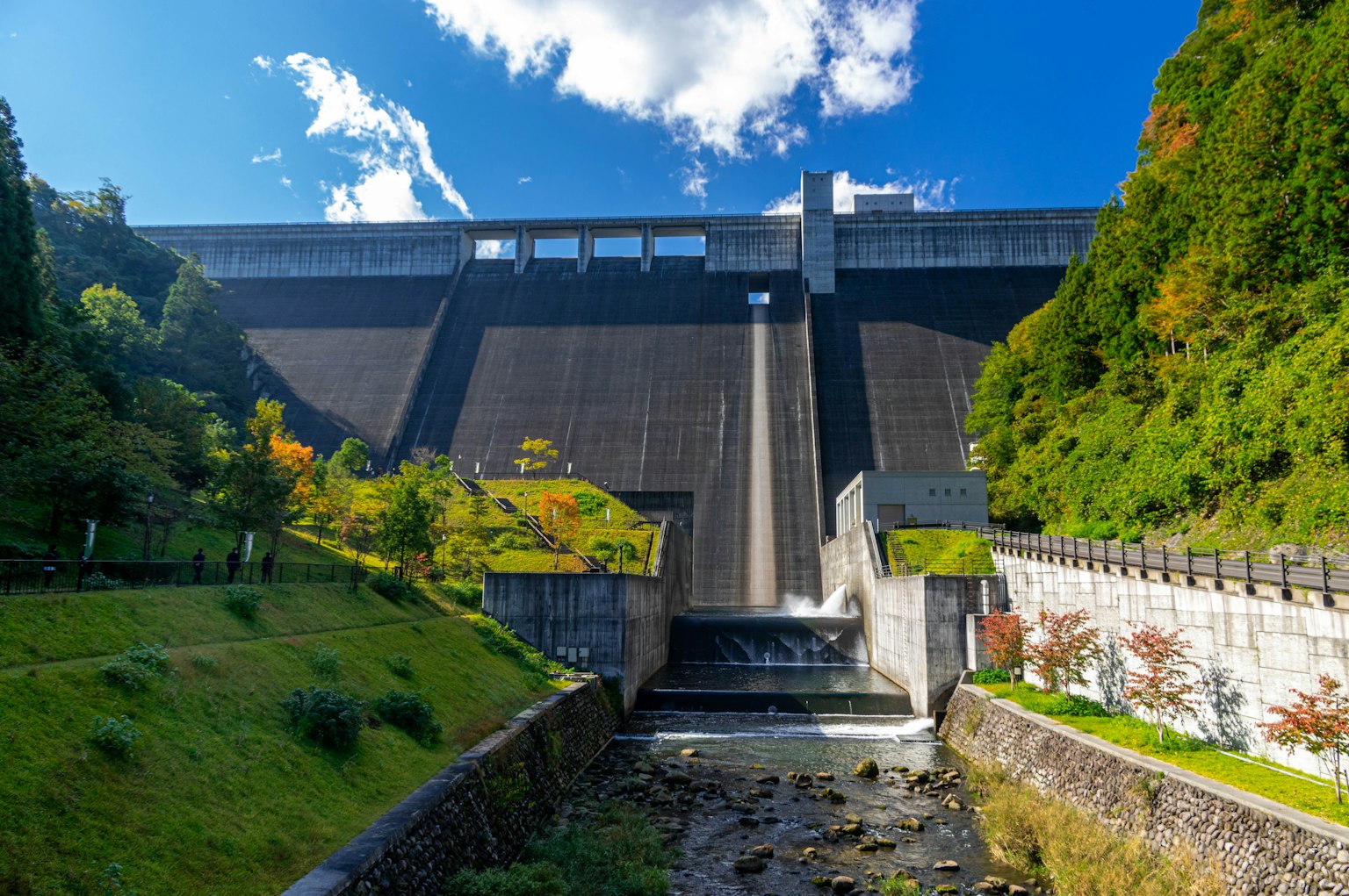 Scenic view of a dam with green grass and a flowing stream