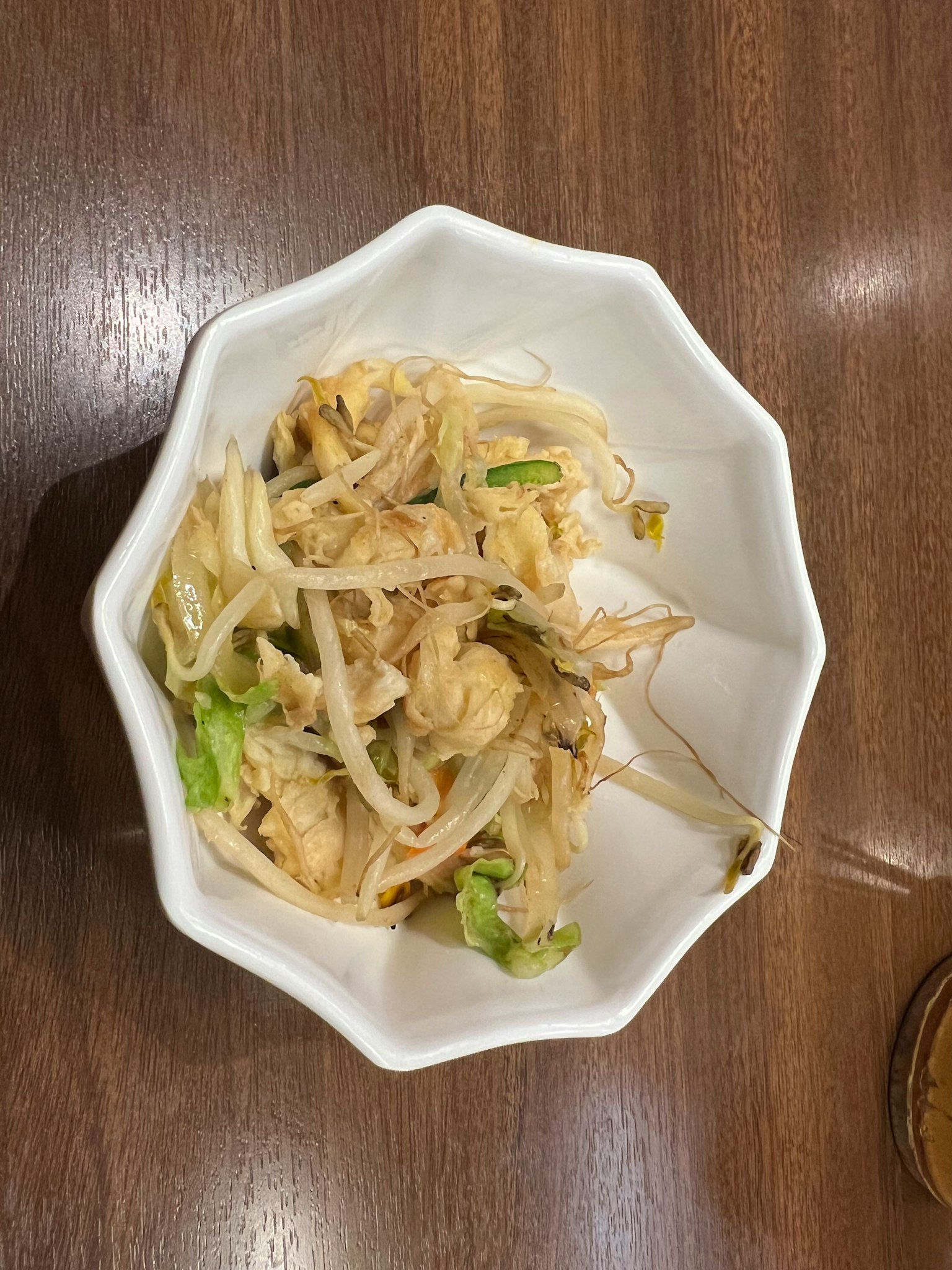 จานไก่ฉีกและผักที่เสิร์ฟในชามแปดเหลี่ยมสีขาว