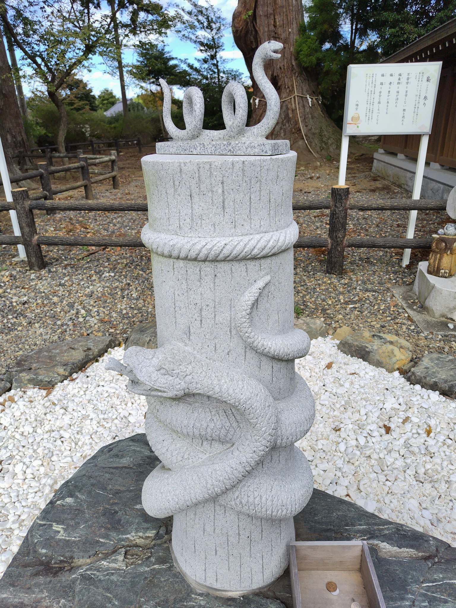 A white stone sculpture of a snake wrapped around a pillar