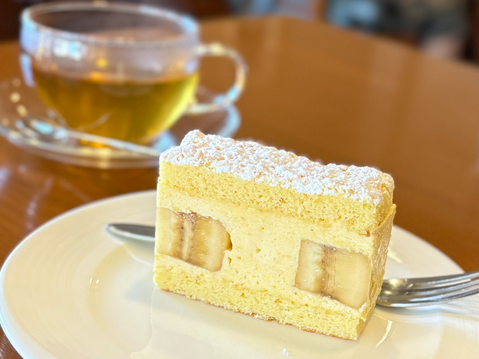 黄色蛋糕与分层馅料和咖啡桌上的一杯茶