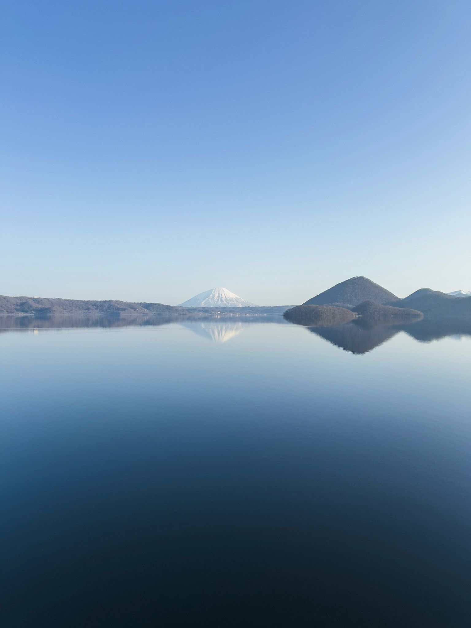 Ruhiger See, der den Fuji-Berg und die umliegenden Berge spiegelt