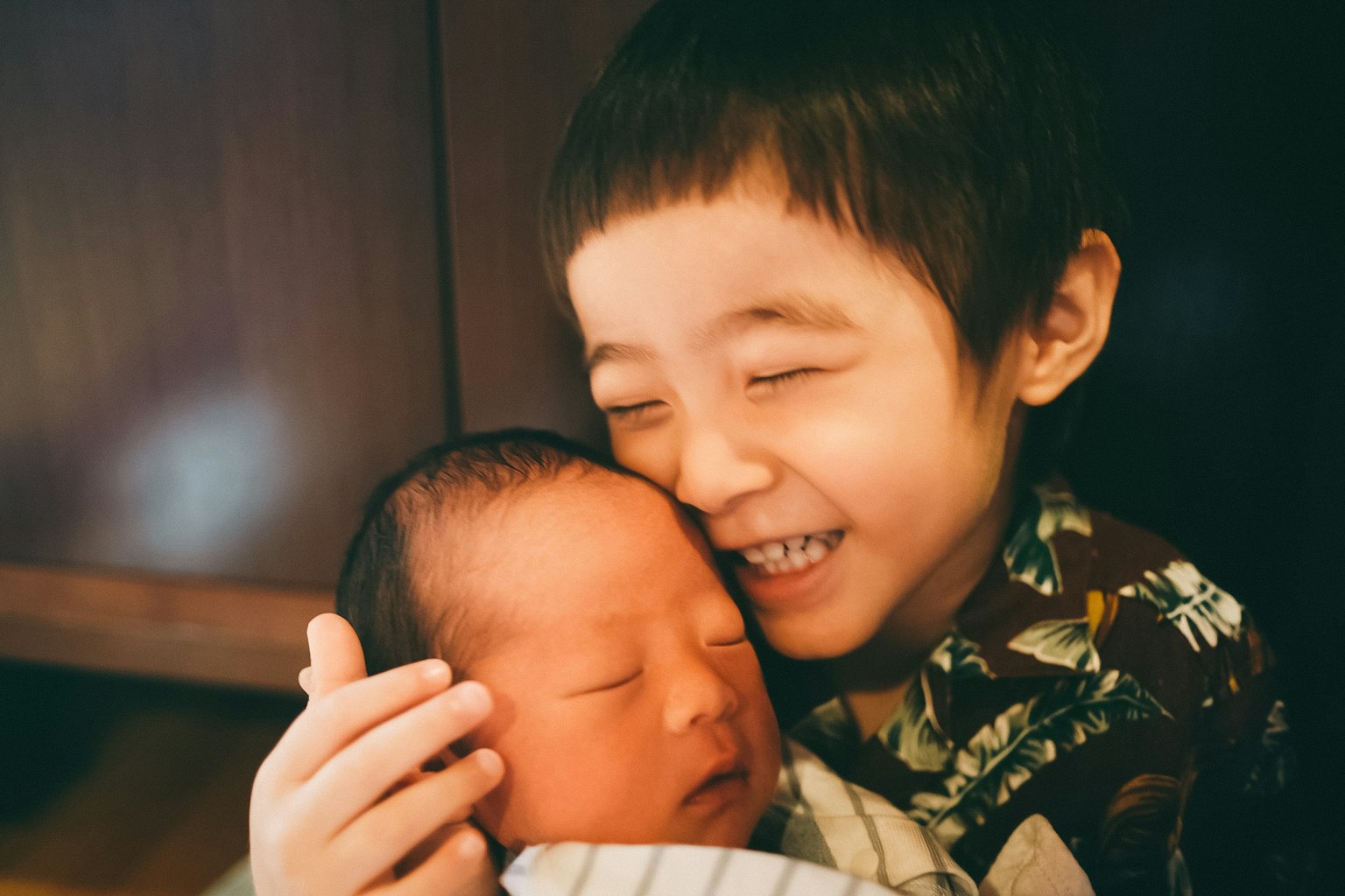 一個快樂的哥哥擁抱著一個熟睡的嬰兒