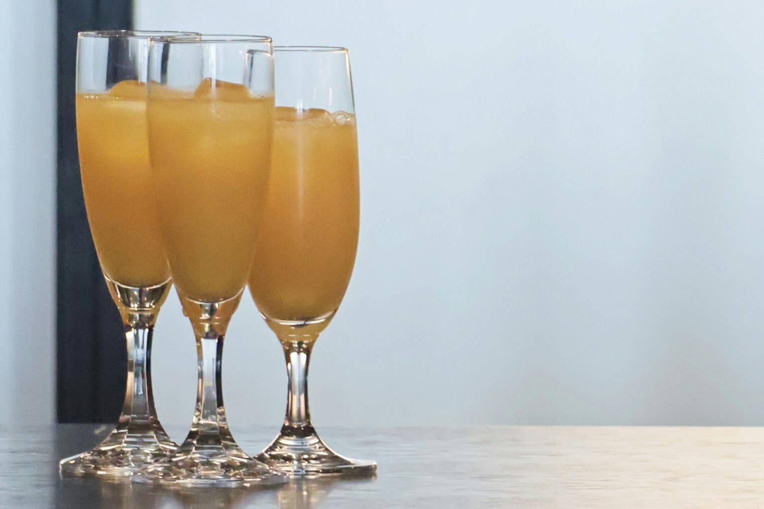 Trois flûtes de champagne remplies de jus d'orange