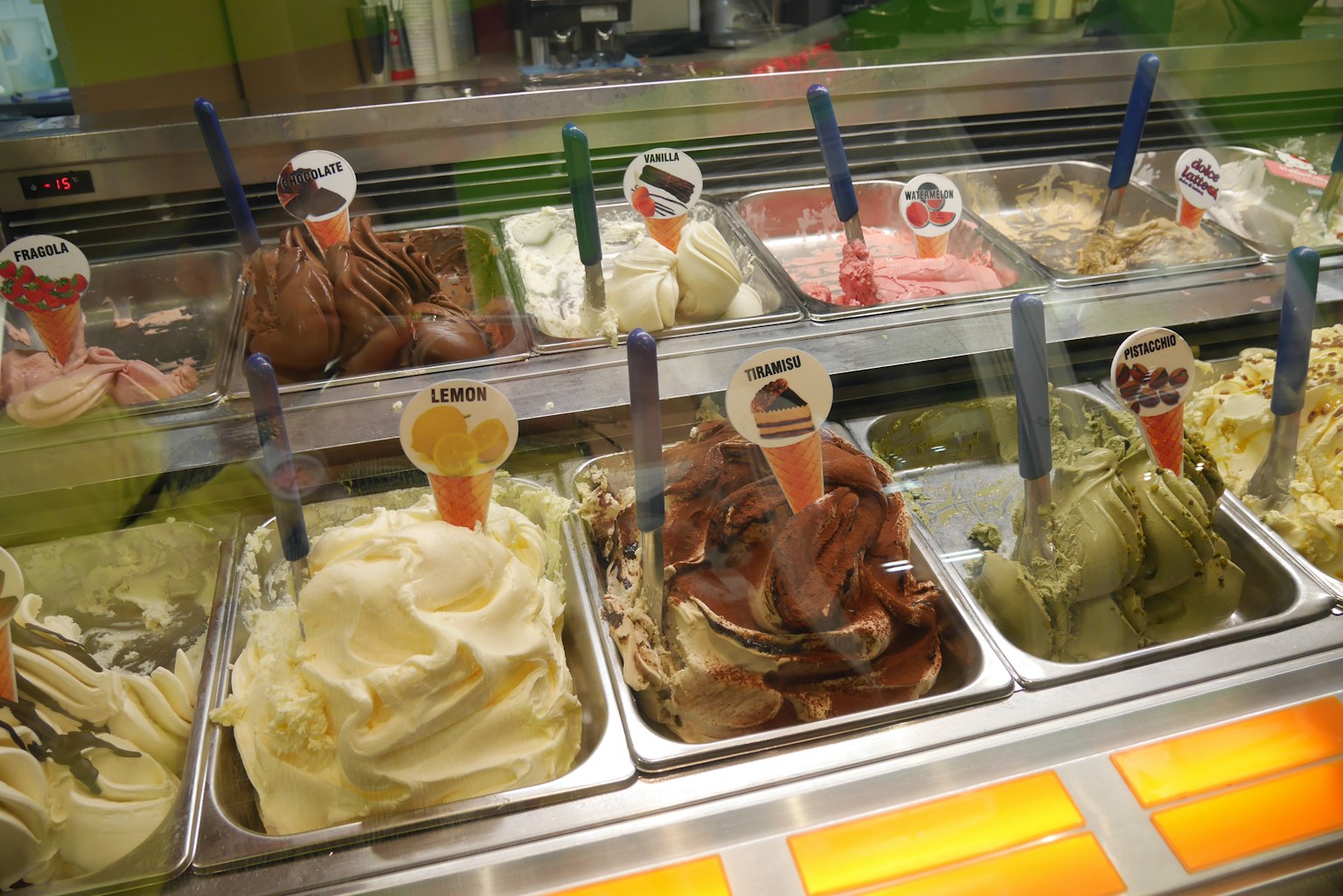 Varietà di gusti di gelato colorati esposti in una vetrina