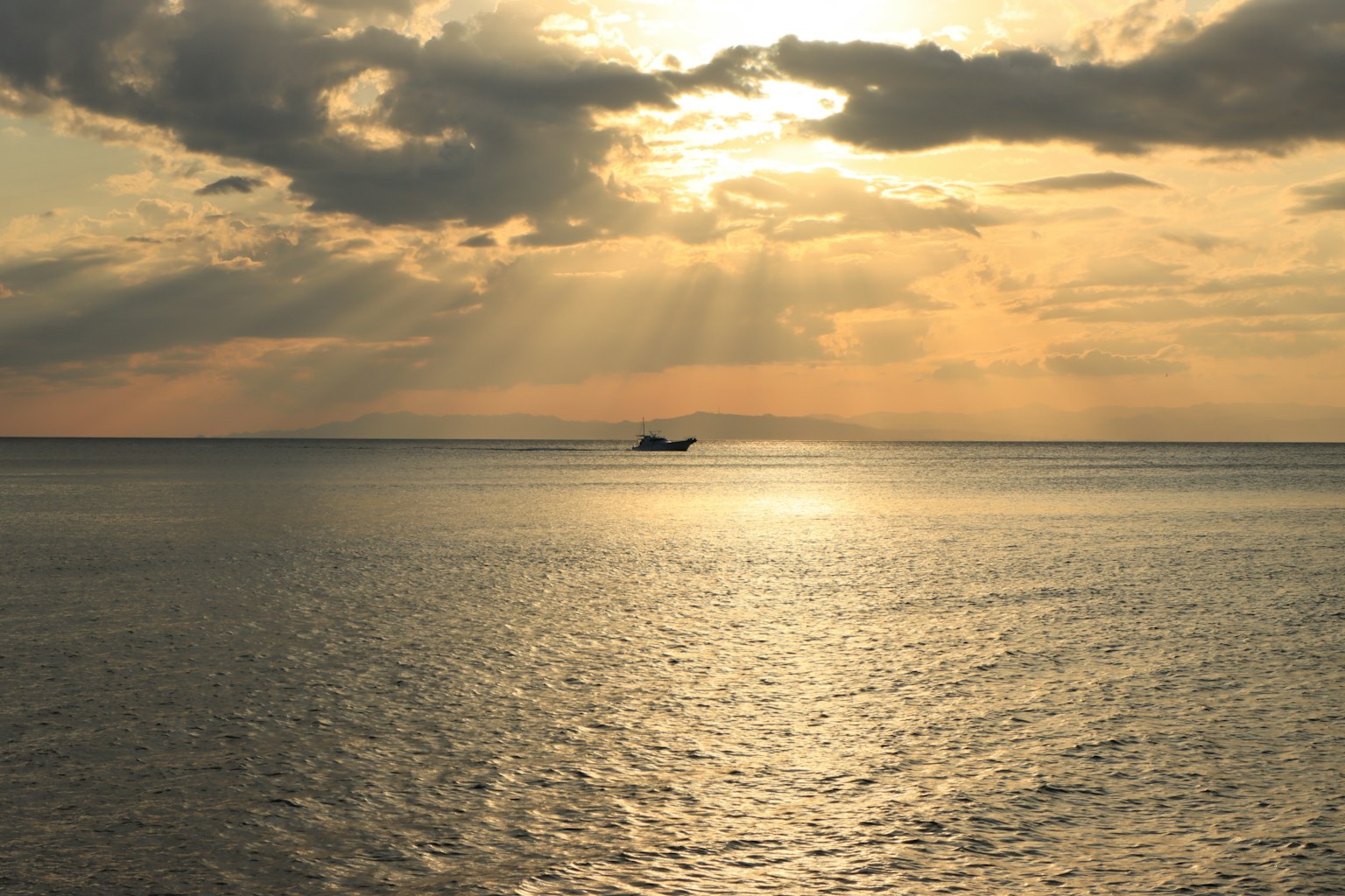 Un paesaggio marino sereno al tramonto con una piccola barca in silhouette