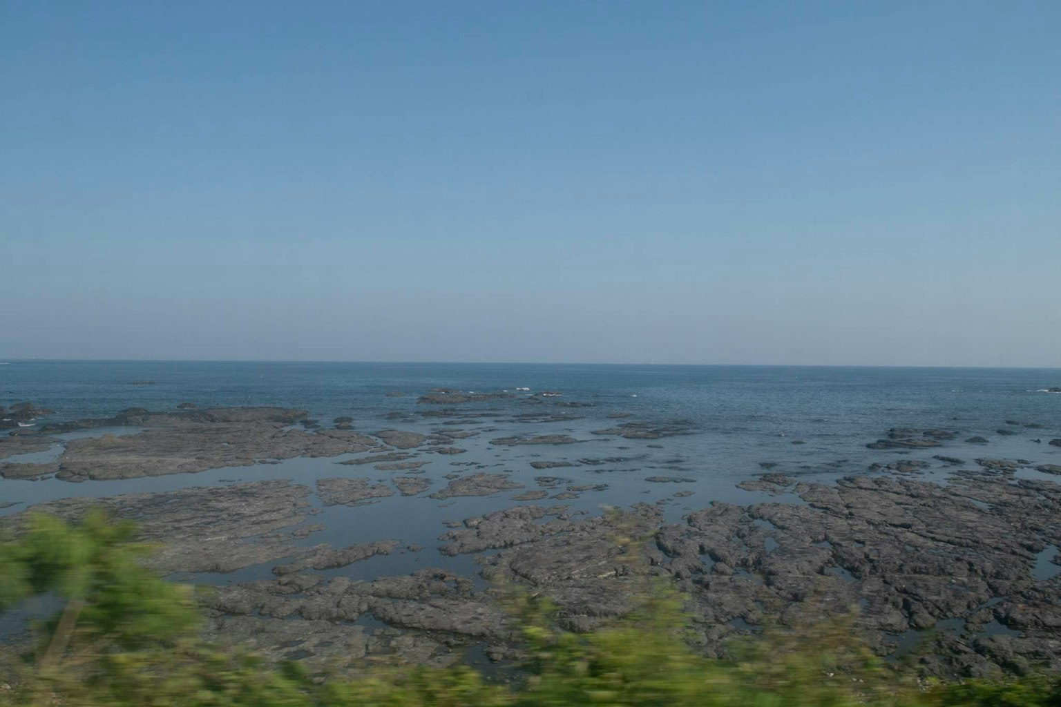 Vista amplia de un océano azul con costa rocosa