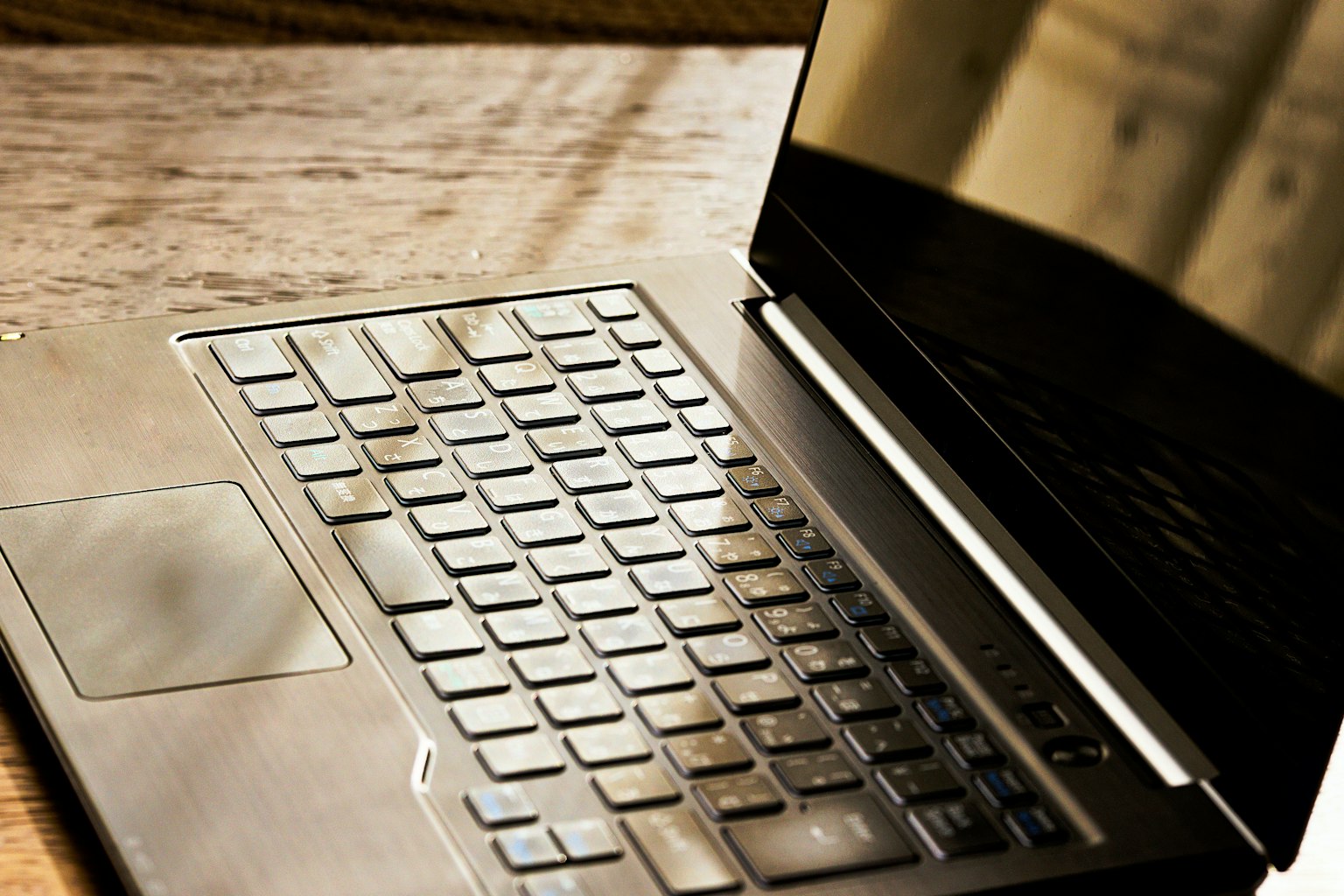 Primo piano di una tastiera di laptop su un tavolo di legno
