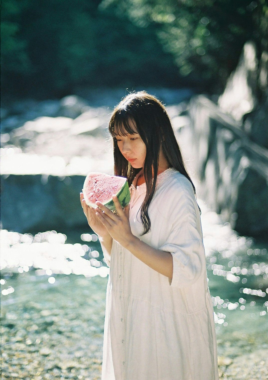 川辺でスイカのかき氷を持つ女性