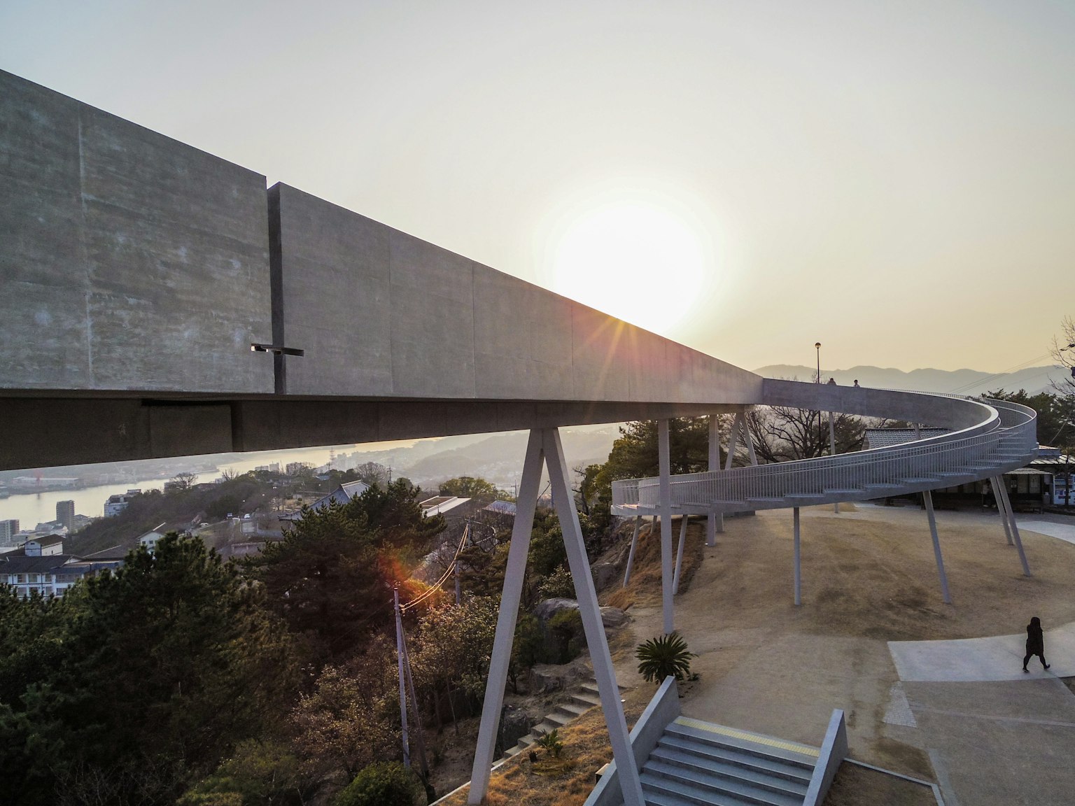 Pasarela elevada de concreto con puesta de sol al fondo