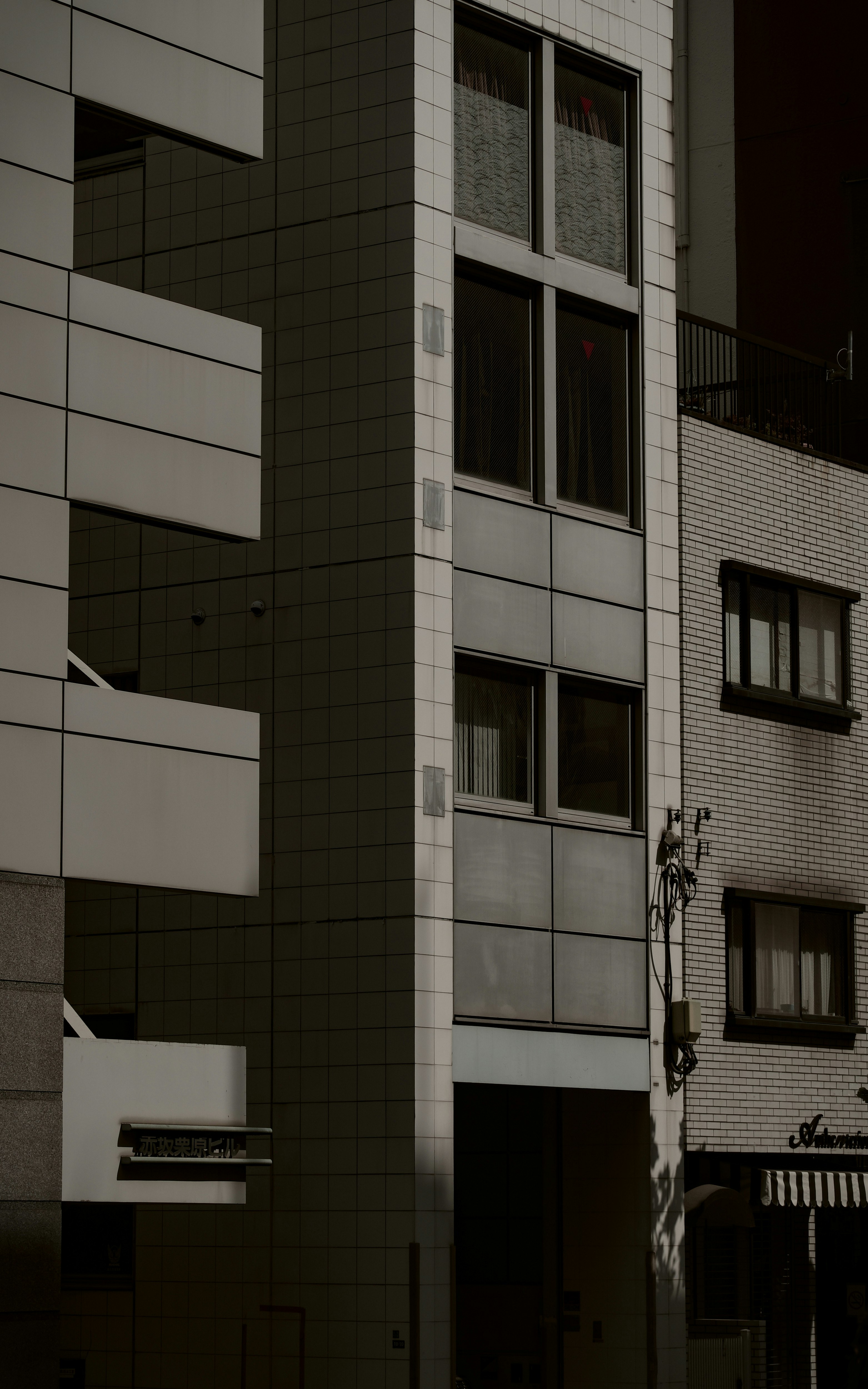 白い外壁の現代的な建物の一部 窓が整然と配置されている